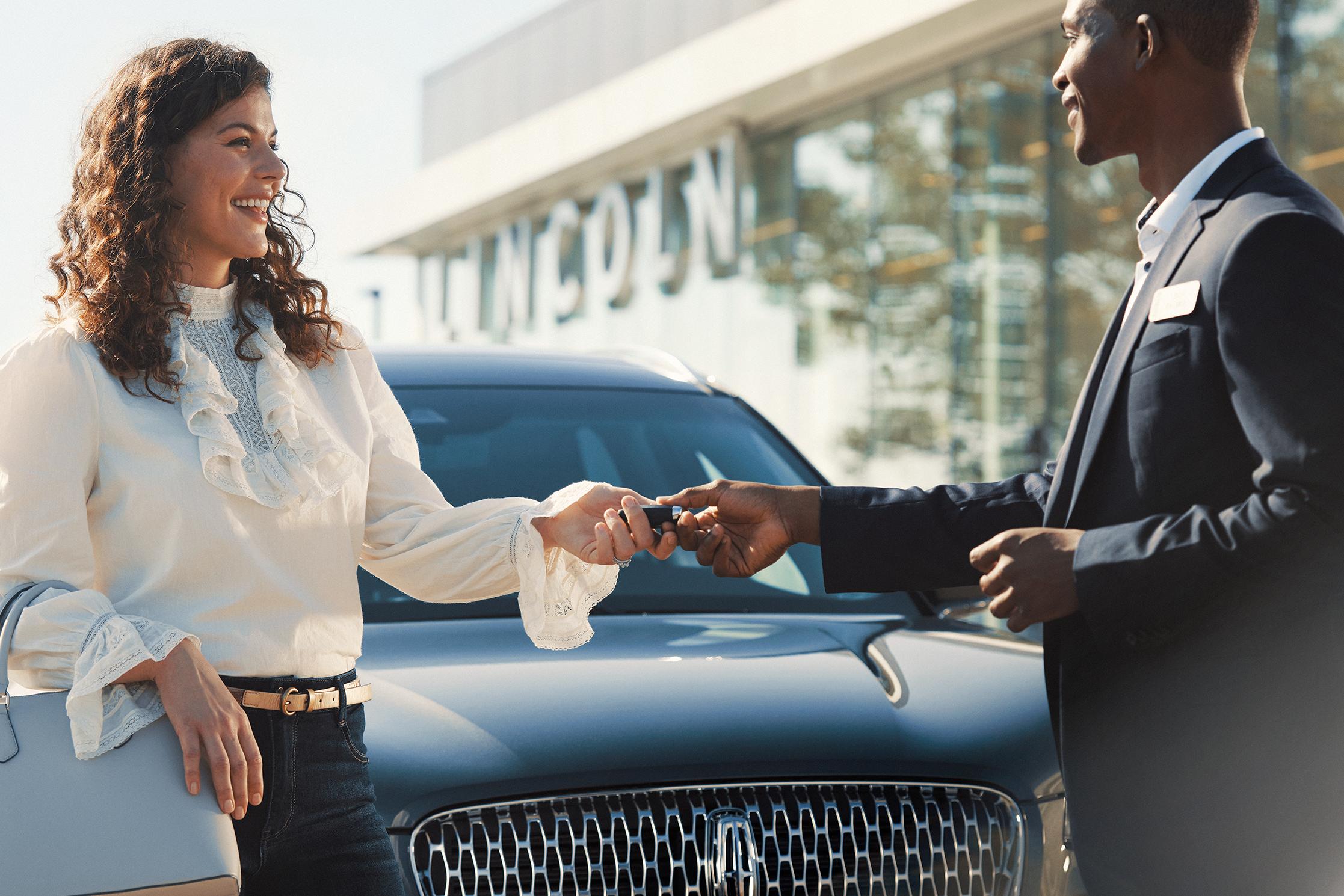 A woman picking up her Lincoln vehicle.