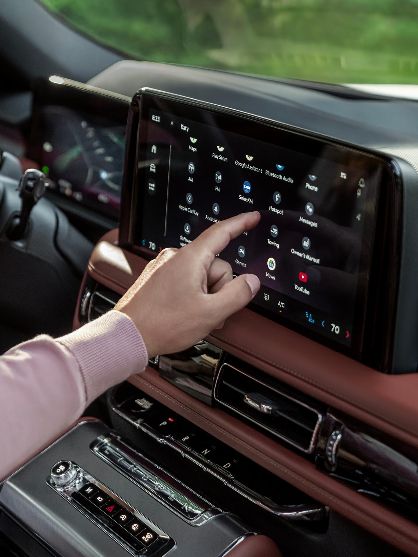 A man using the center touchscreen on his Lincoln Aviator