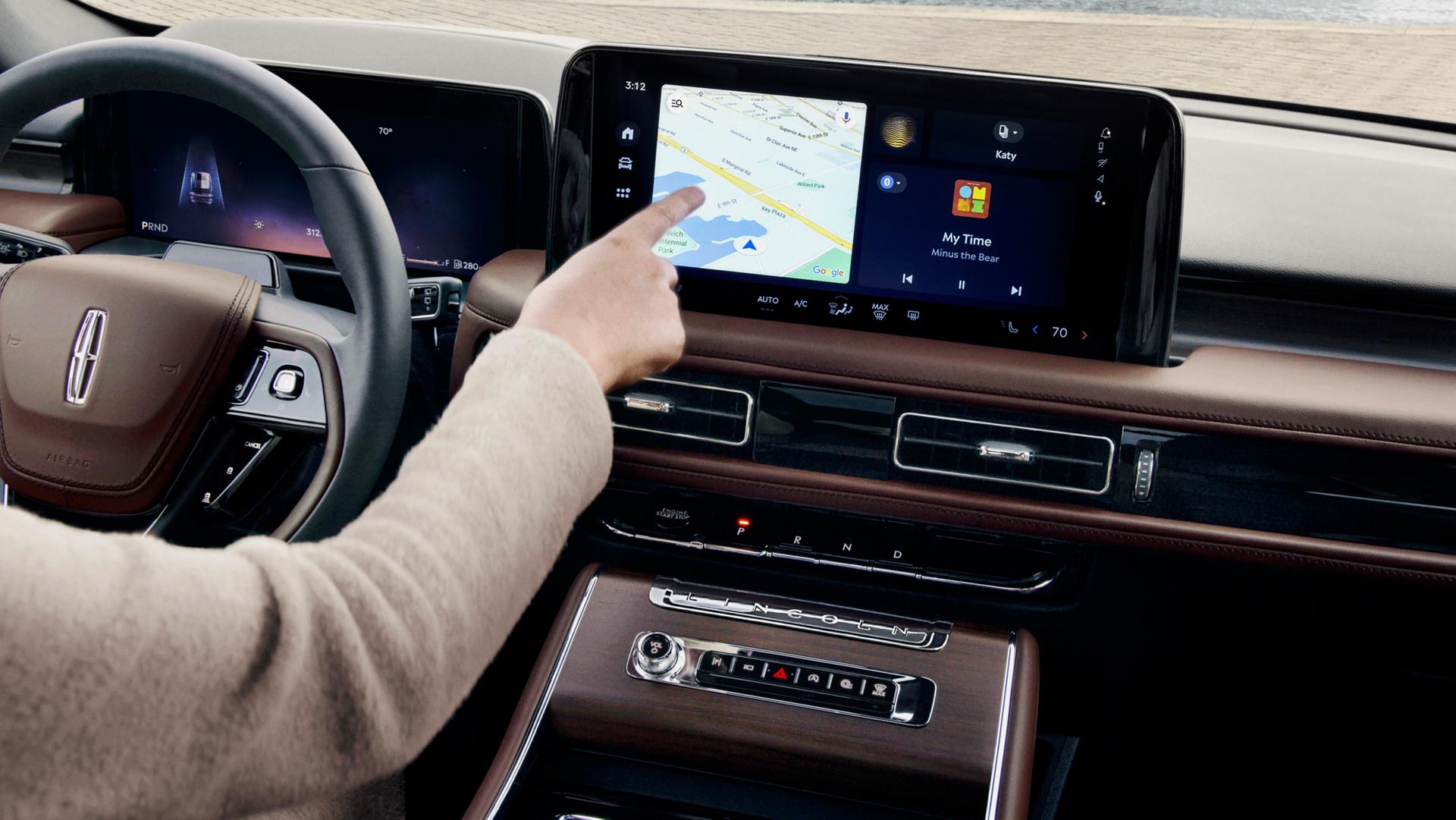 The driver of a 2026 Lincoln Aviator® SUV touches the center touchscreen