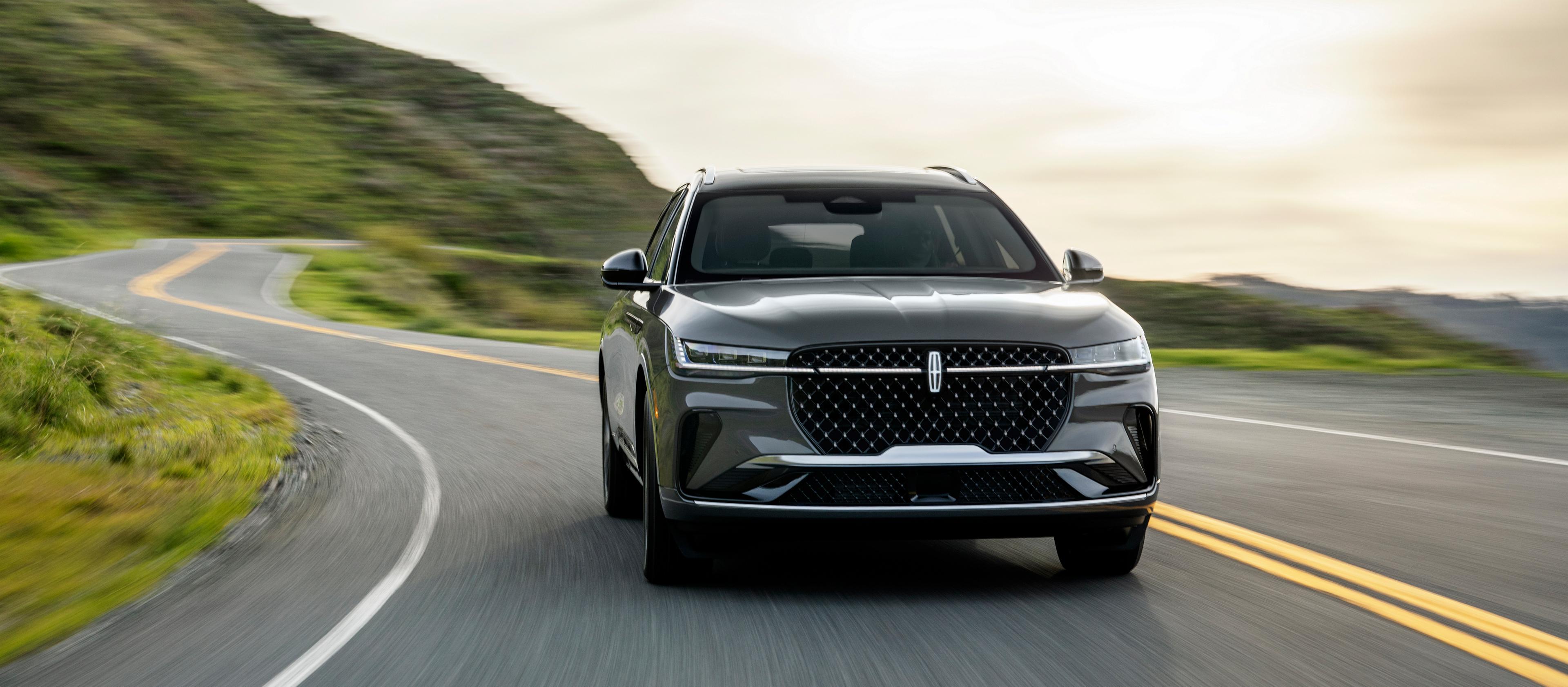 A 2026 Lincoln Black Label™ Nautilus® SUV is being driven on a waterfront roadway