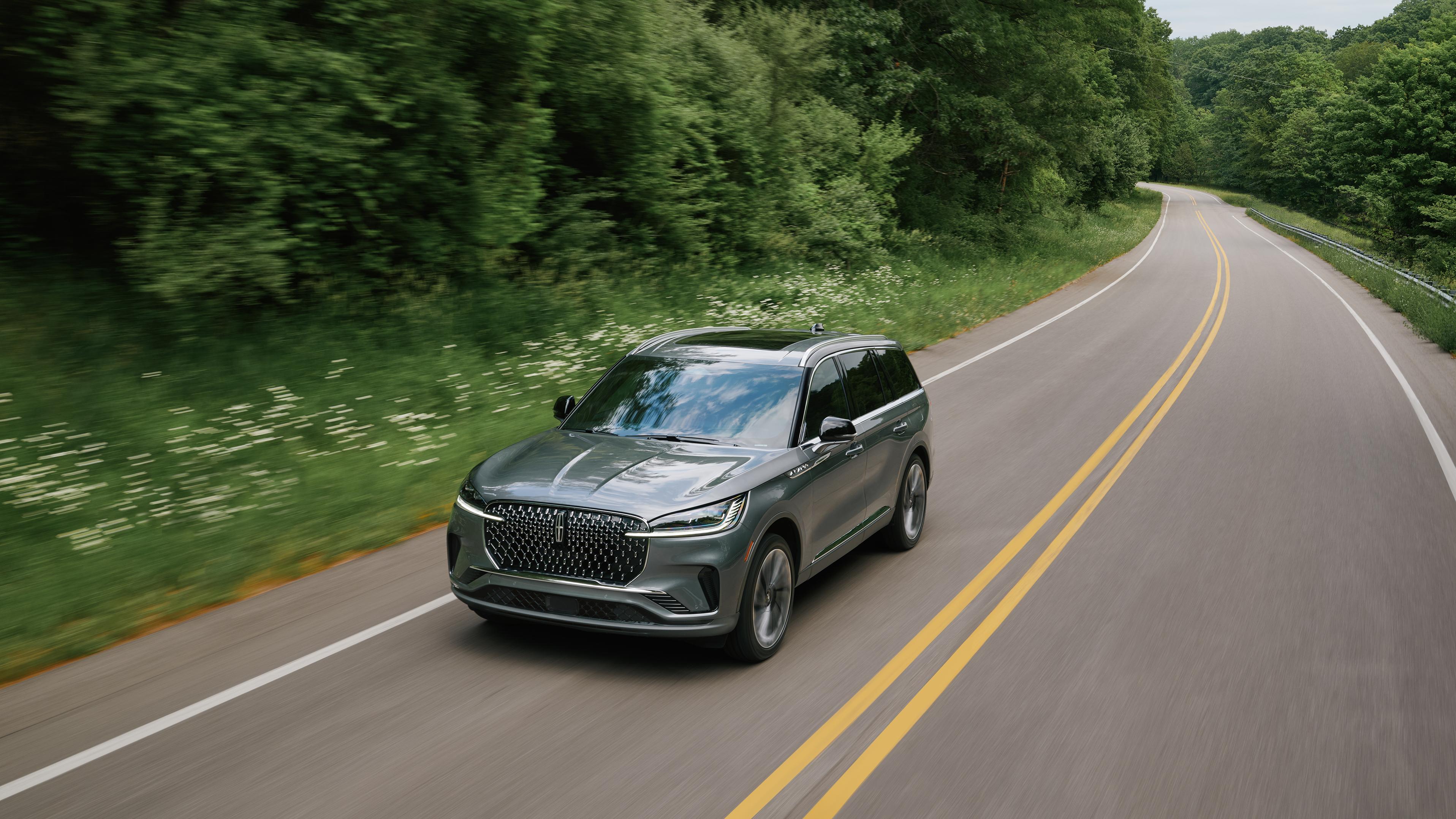 A 2027 Lincoln Aviator® SUV is being driven on a country road
