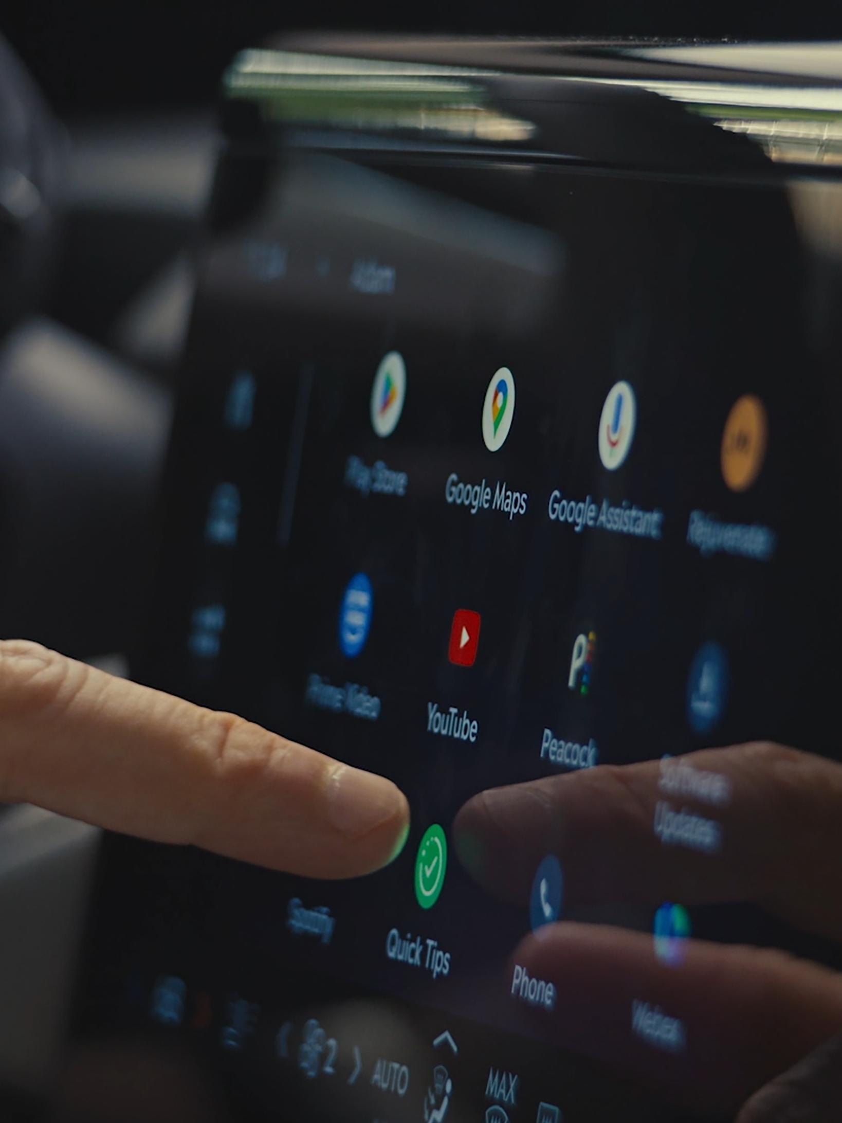 A person uses the center touch screen to receive driving tips