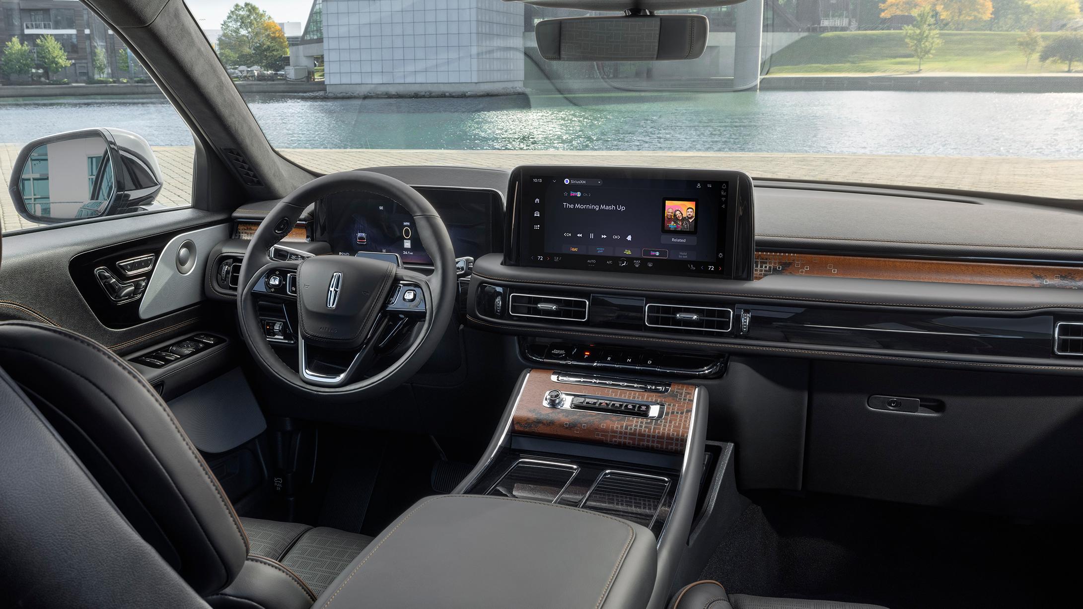 Lincoln center console and infotainment screen playing SiriusXM's "The Morning Mash Up" with climate and media controls visible.