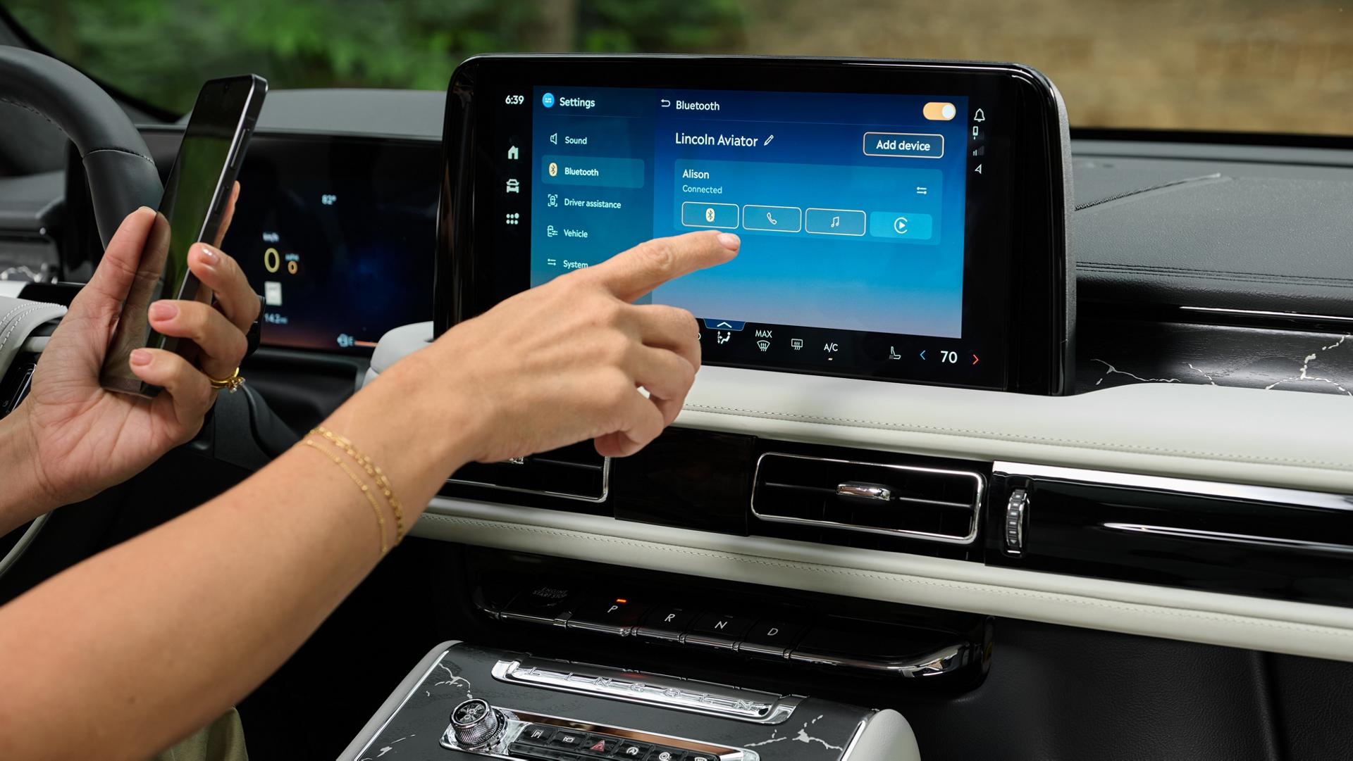 A 2027 Lincoln Aviator® SUV owner interacts with the digital display to configure and use the Wi-Fi® hotspot