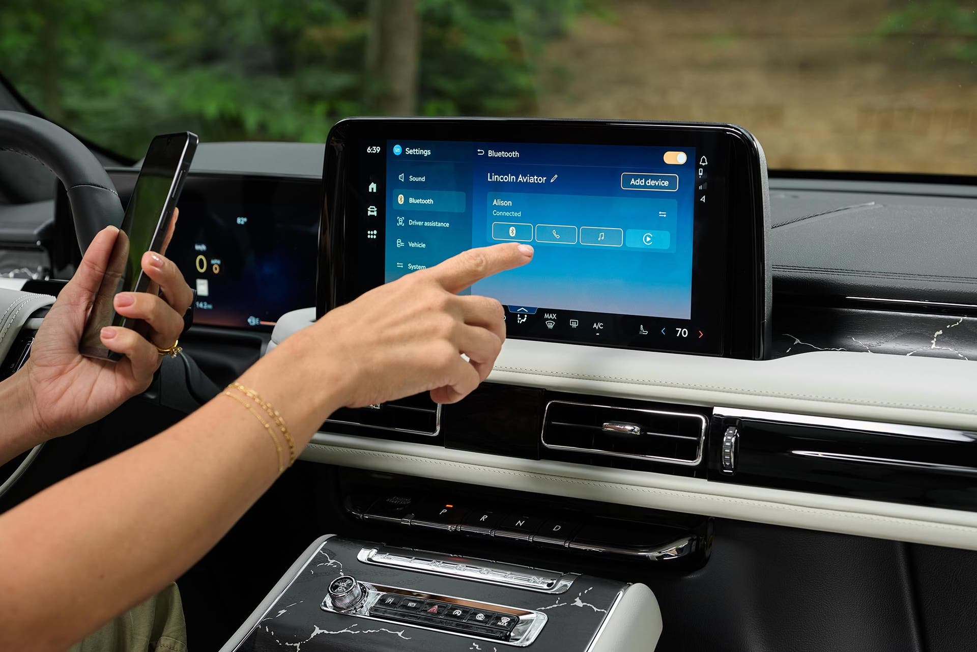 The driver of a 2027 Lincoln Aviator® SUV interacts with the center touchscreen