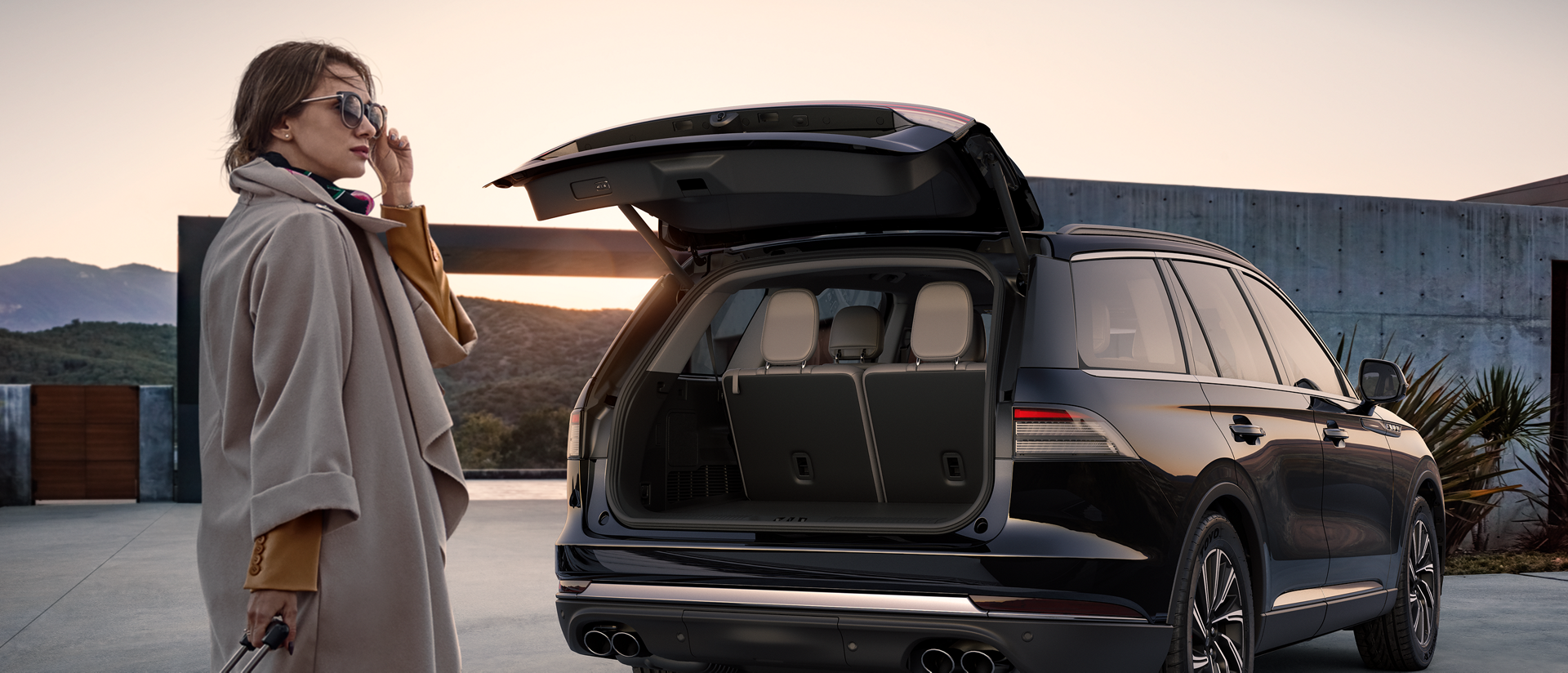 A woman standing outside her Lincoln vehicle.