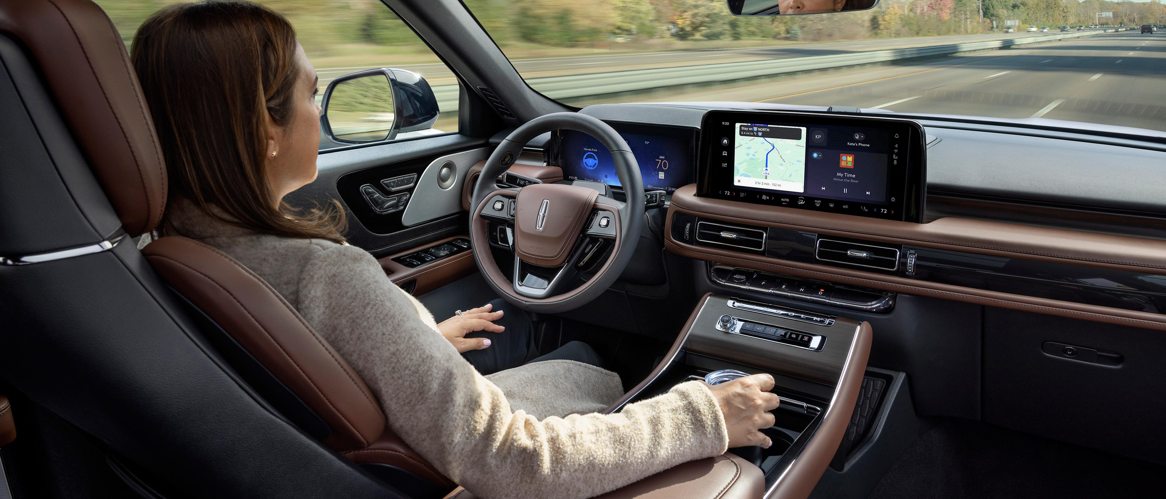 Una mujer utiliza la SUV Lincoln Aviator® 2026 con manos libres y con la vista en la carretera mediante Lincoln BlueCruise