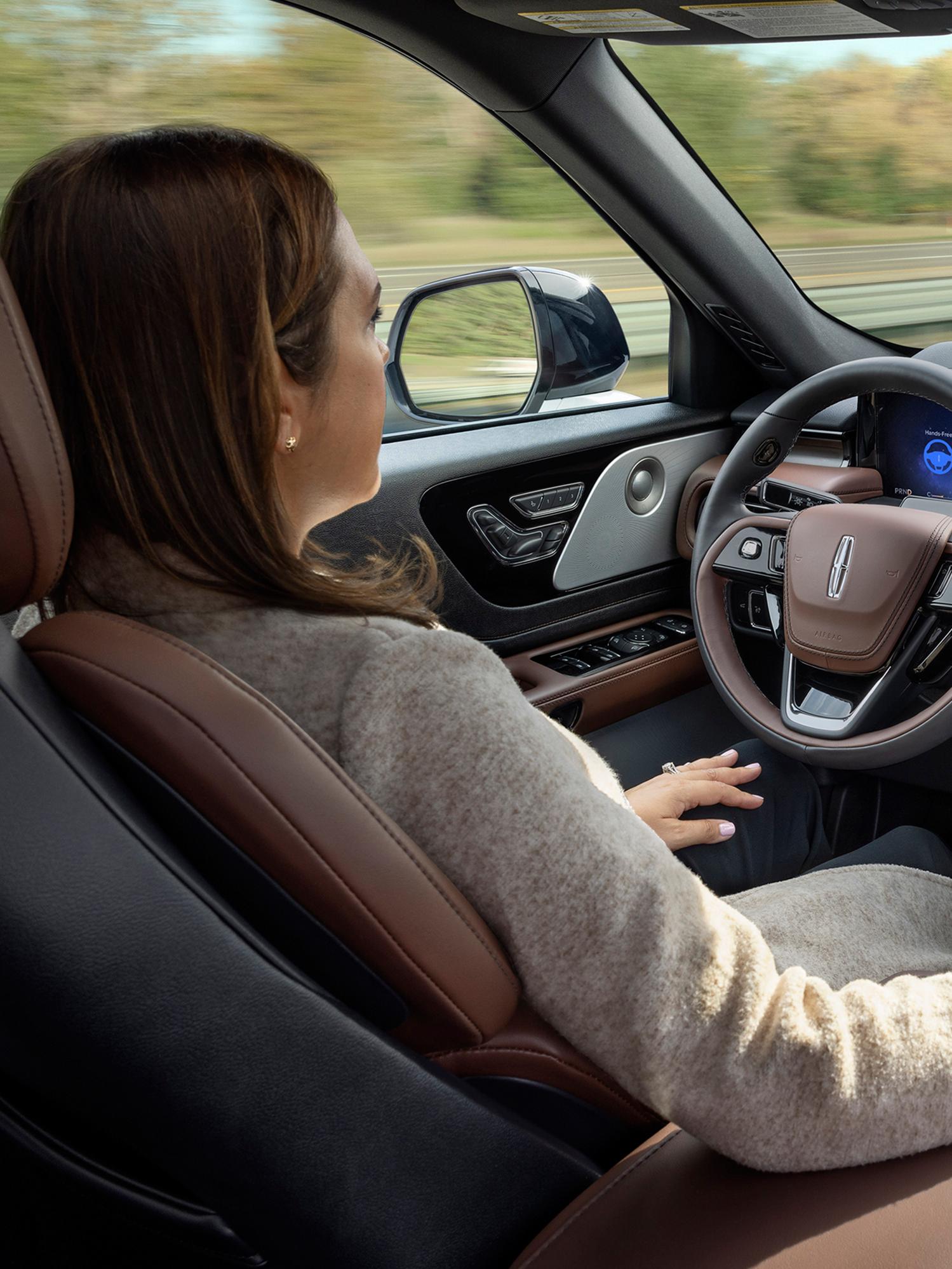 Una mujer utiliza la SUV Lincoln Aviator® 2026 con manos libres y con la vista en la carretera mediante Lincoln BlueCruise