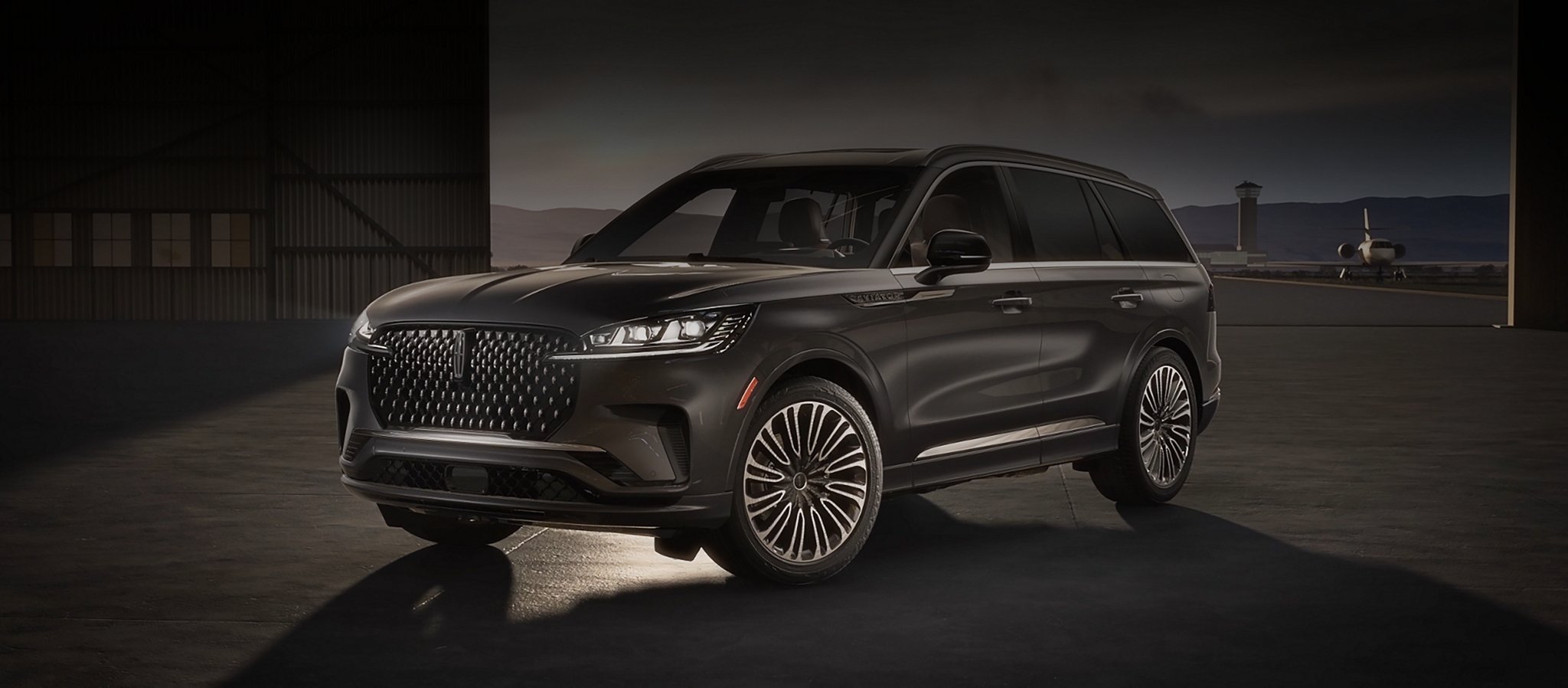 A Lincoln Black Label Aviator® SUV is parked in a private airplane hangar.