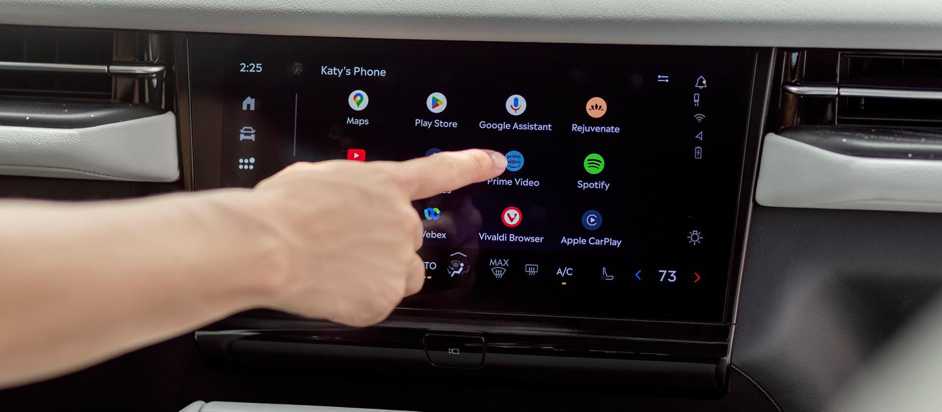 A person interacts with the center display to access apps for streaming, gaming, and working