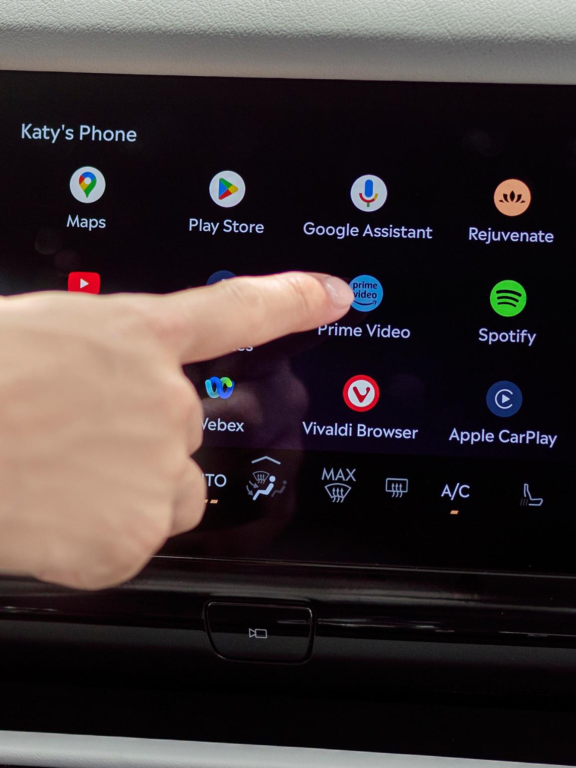 A person interacts with the center display to access apps for streaming, gaming, and working