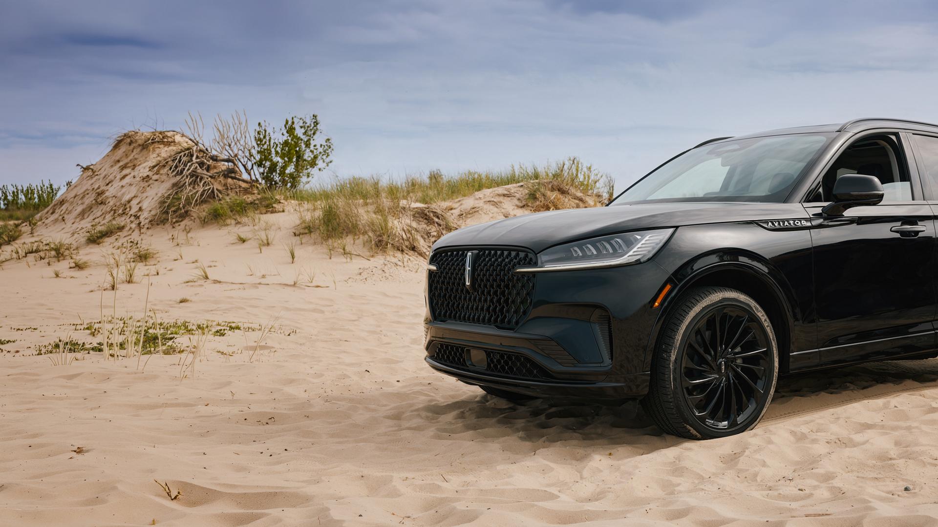 A 2027 Lincoln Aviator® SUV is parked near lakeshore sand dunes