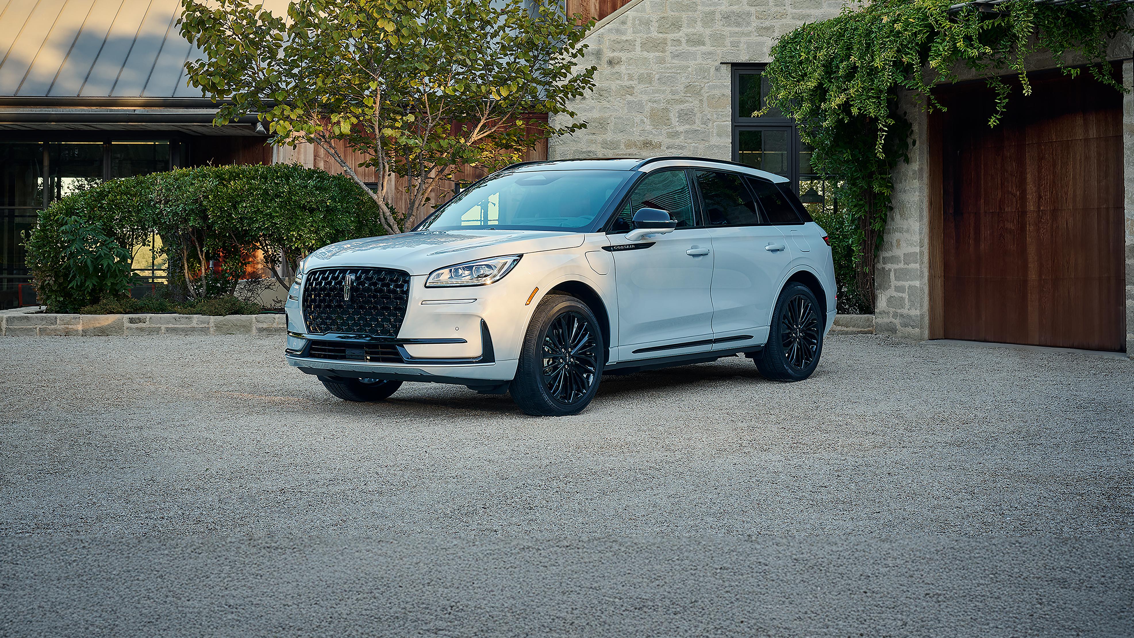 A 2025 Lincoln Corsair® parked in a driveway with a house and greenery in the background