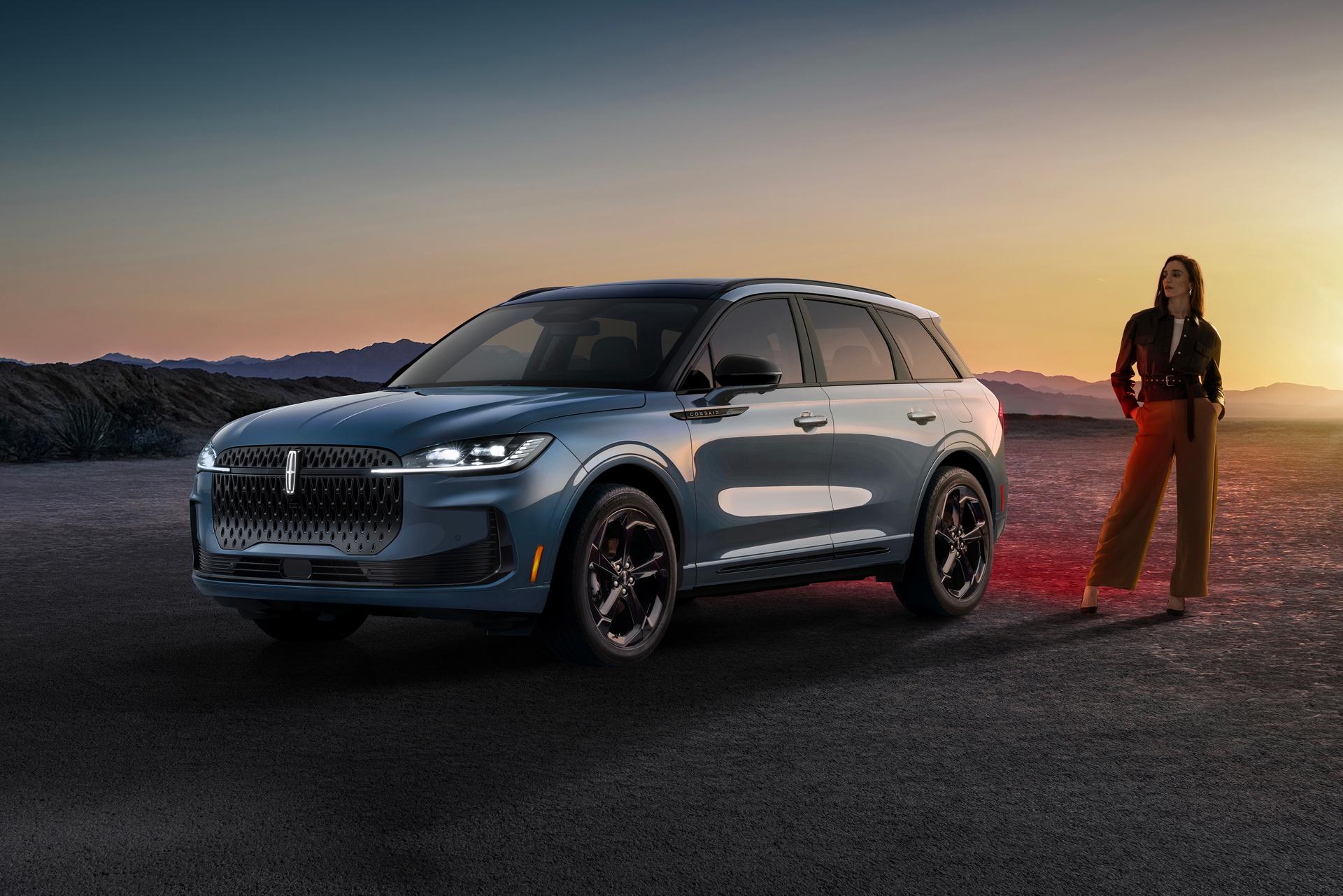 A stylishly dressed woman standing next to a 2027 Lincoln Corsair® Hybrid parked in a dramatic desert landscape