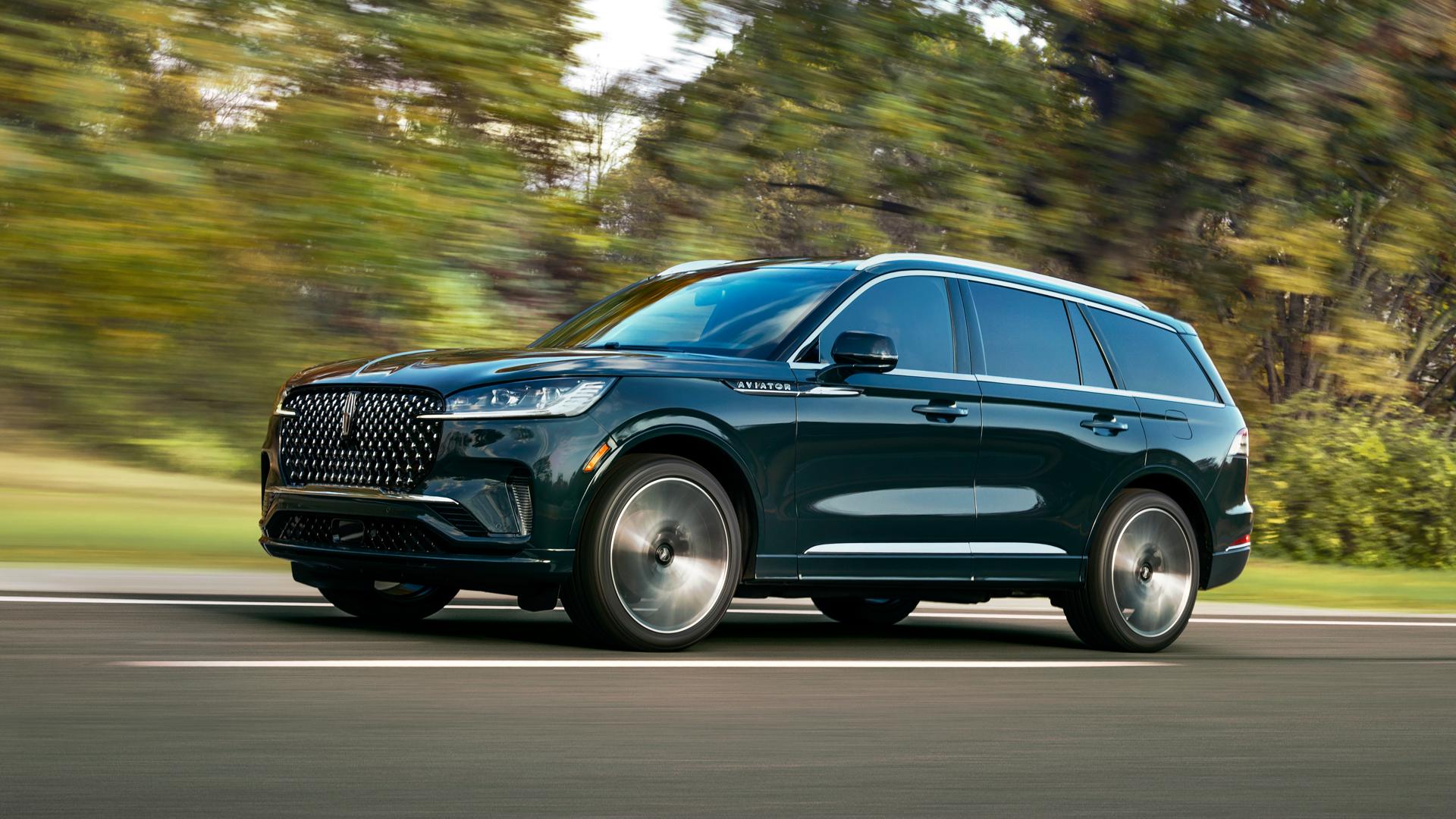 A 2026 Lincoln Aviator® SUV is shown driving on a forested road