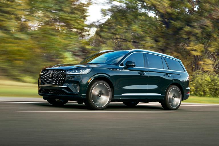 A 2026 Lincoln Aviator® SUV is shown driving on a forested road