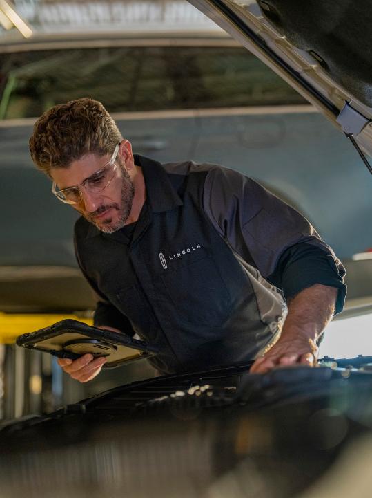 Un técnico de Lincoln está inspeccionando un vehículo Lincoln.