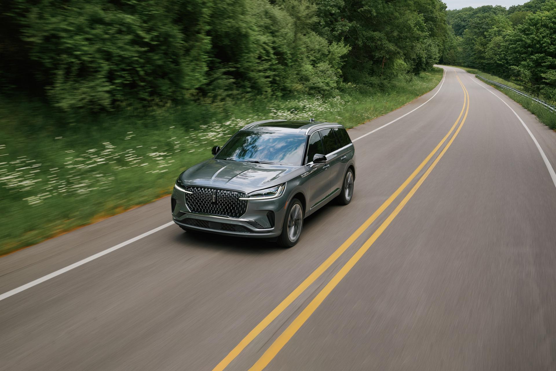 A 2027 Lincoln Aviator® SUV is being driven on a country road
