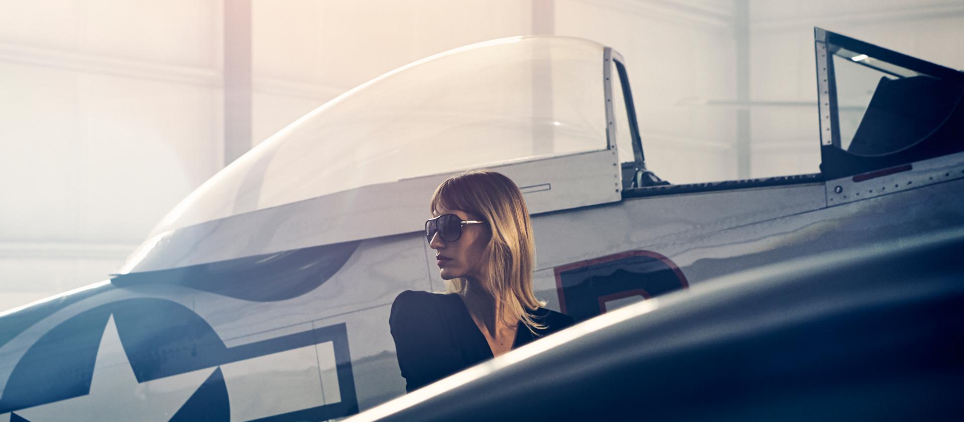  A woman is shown next to a vintage airplane to evoke the inspiration for the 2025 Lincoln Black Label Flight theme