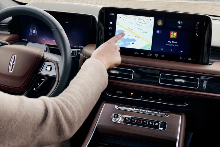 A person is tapping the center-stack touchscreen display of a 2026 Lincoln Aviator® SUV
