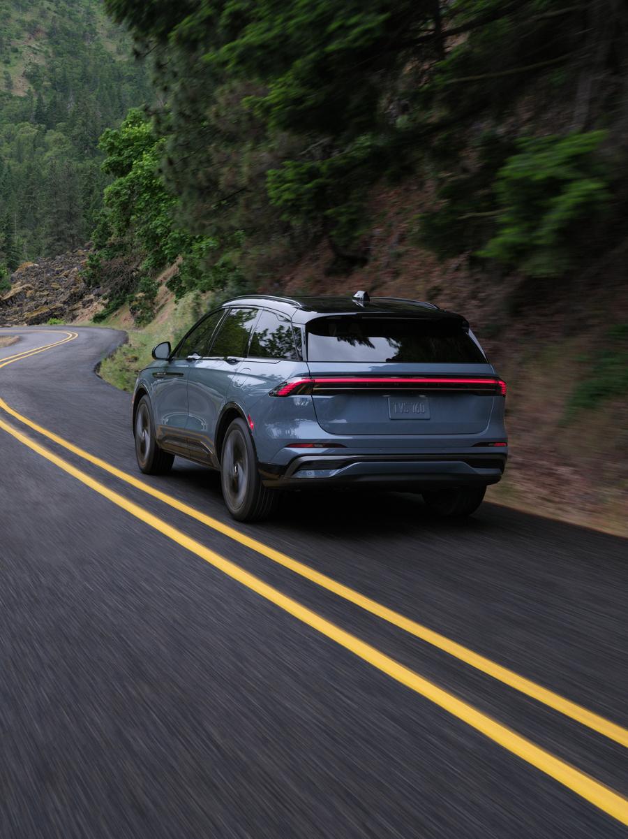 A 2026 Lincoln Nautilus® SUV is being driven through a sharp turn on a rural road