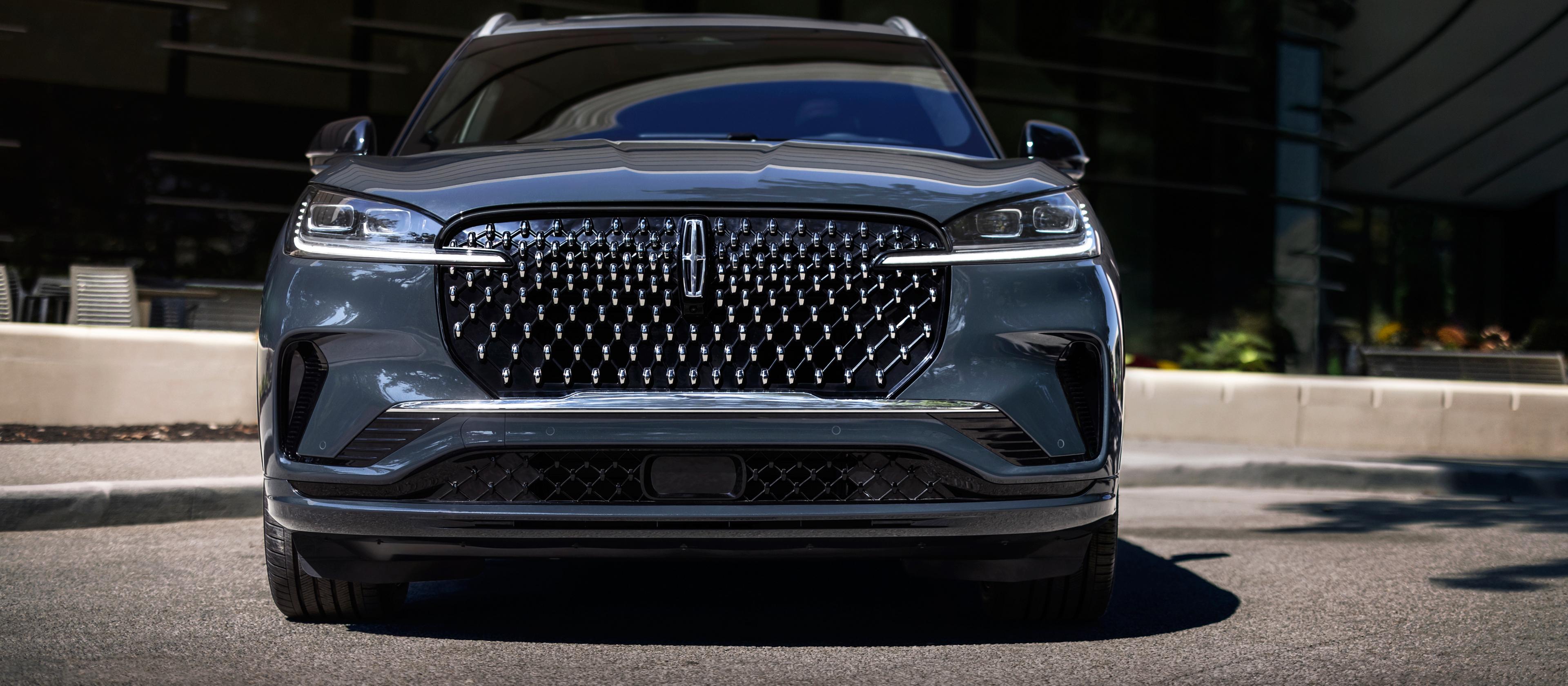 The dazzling grille of a 2026 Lincoln Black Label Aviator® SUV sparkles in the sunlight