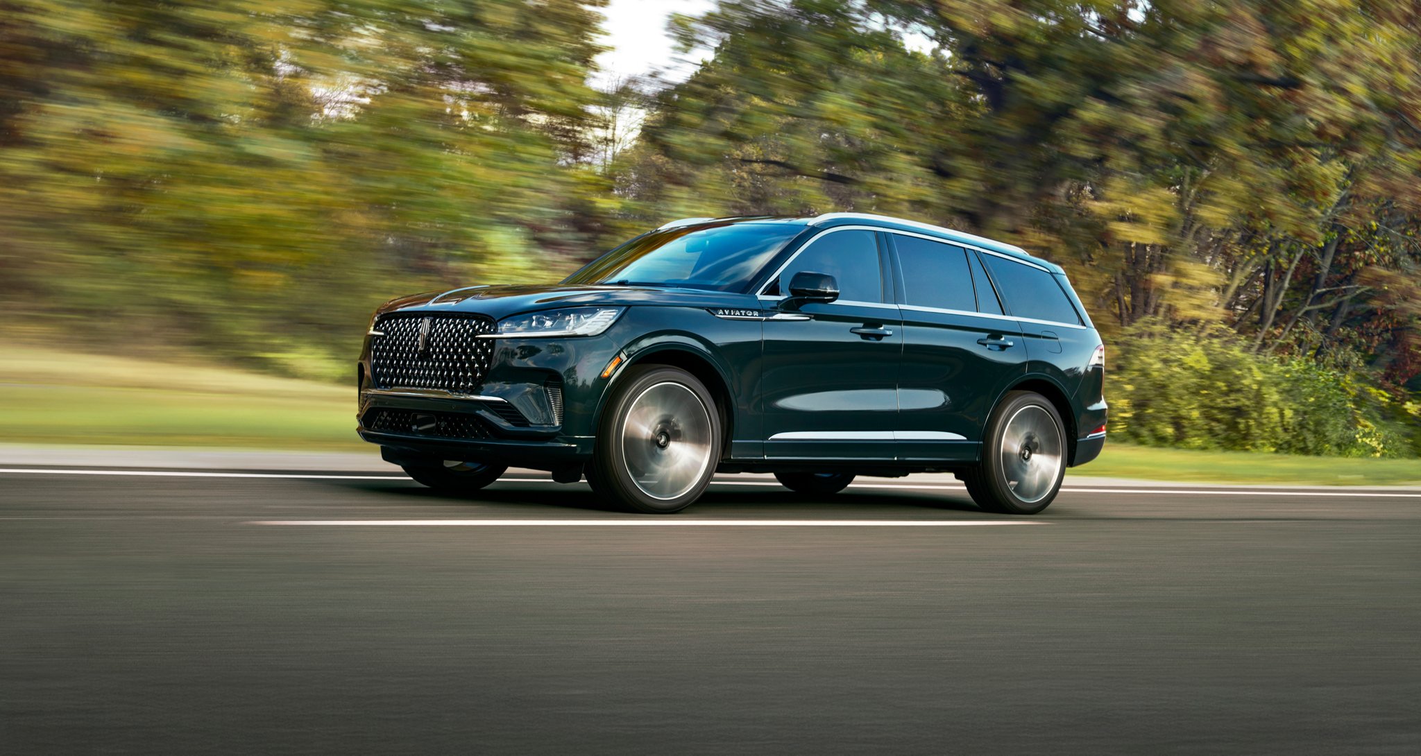 The 2025 Lincoln Aviator driving down a road.
