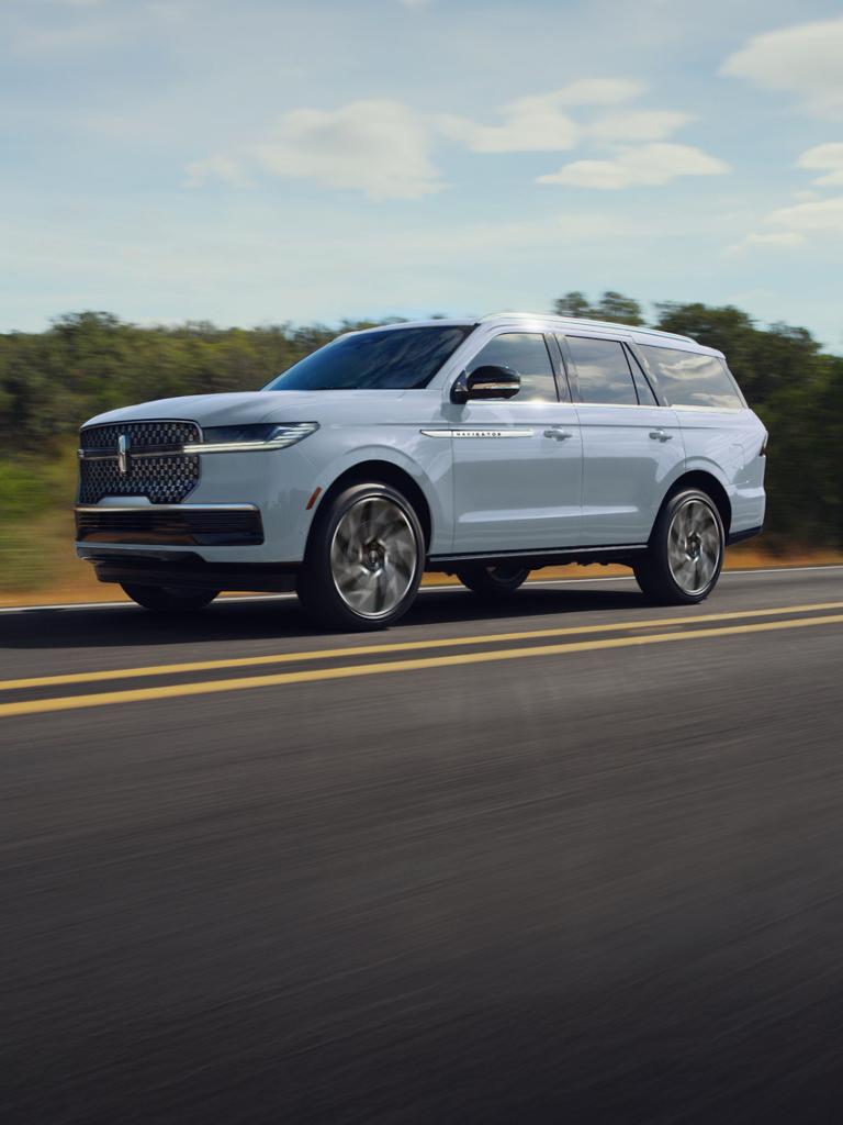 The Lincoln Navigator driving down a road.