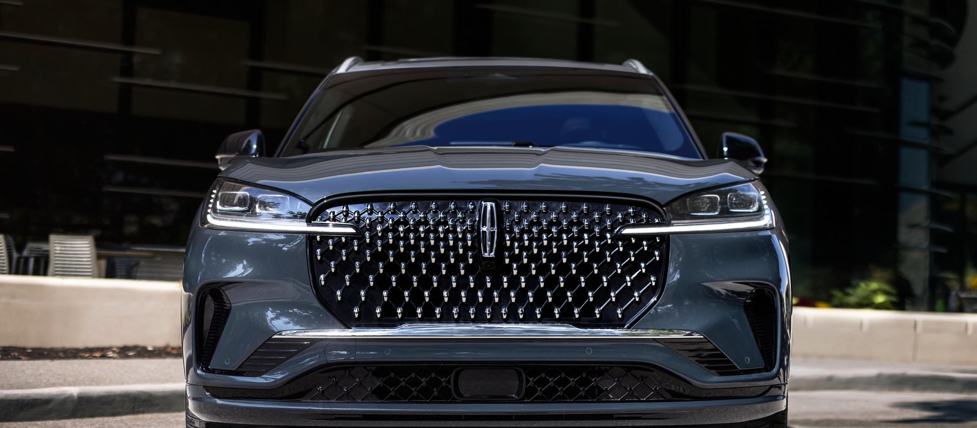 The dazzling grille of a 2025 Lincoln Black Label Aviator® SUV sparkles in the sunlight