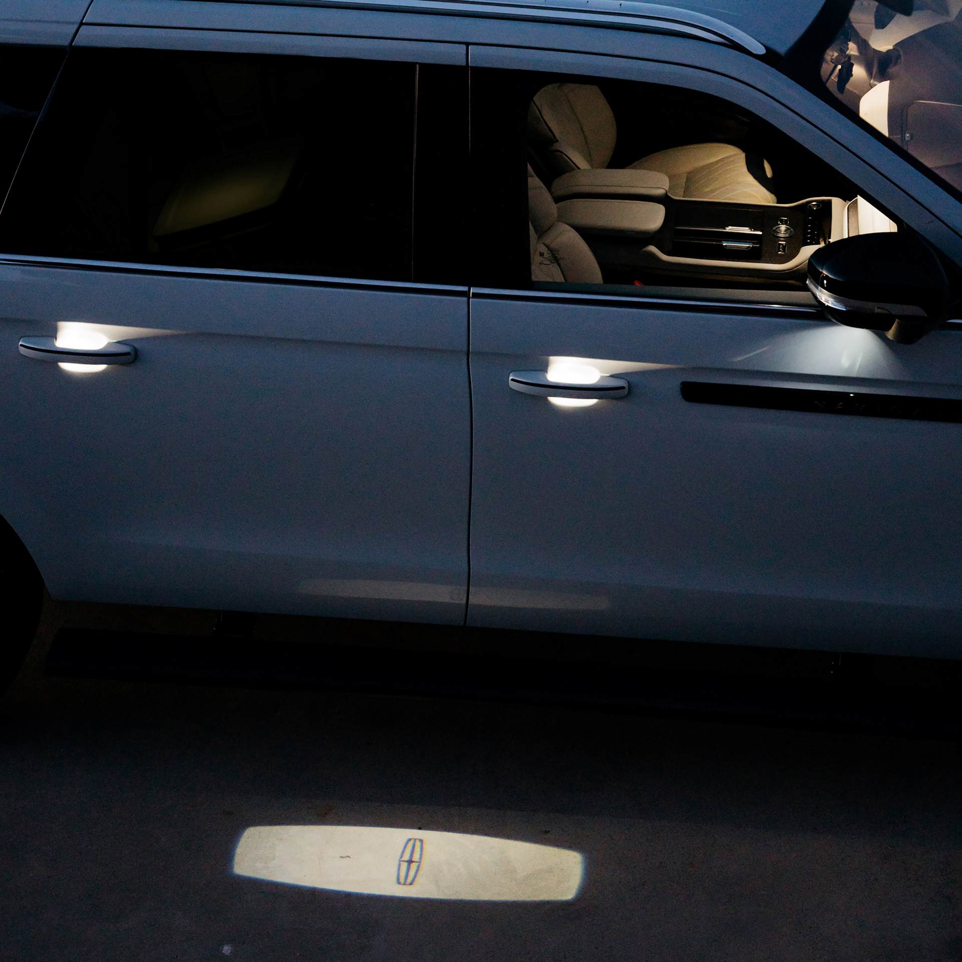 A woman emerges from a 2027 Lincoln Navigator® Black Label™ model