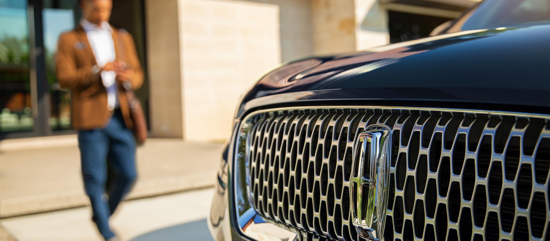 Un hombre caminando hacia su vehículo Lincoln