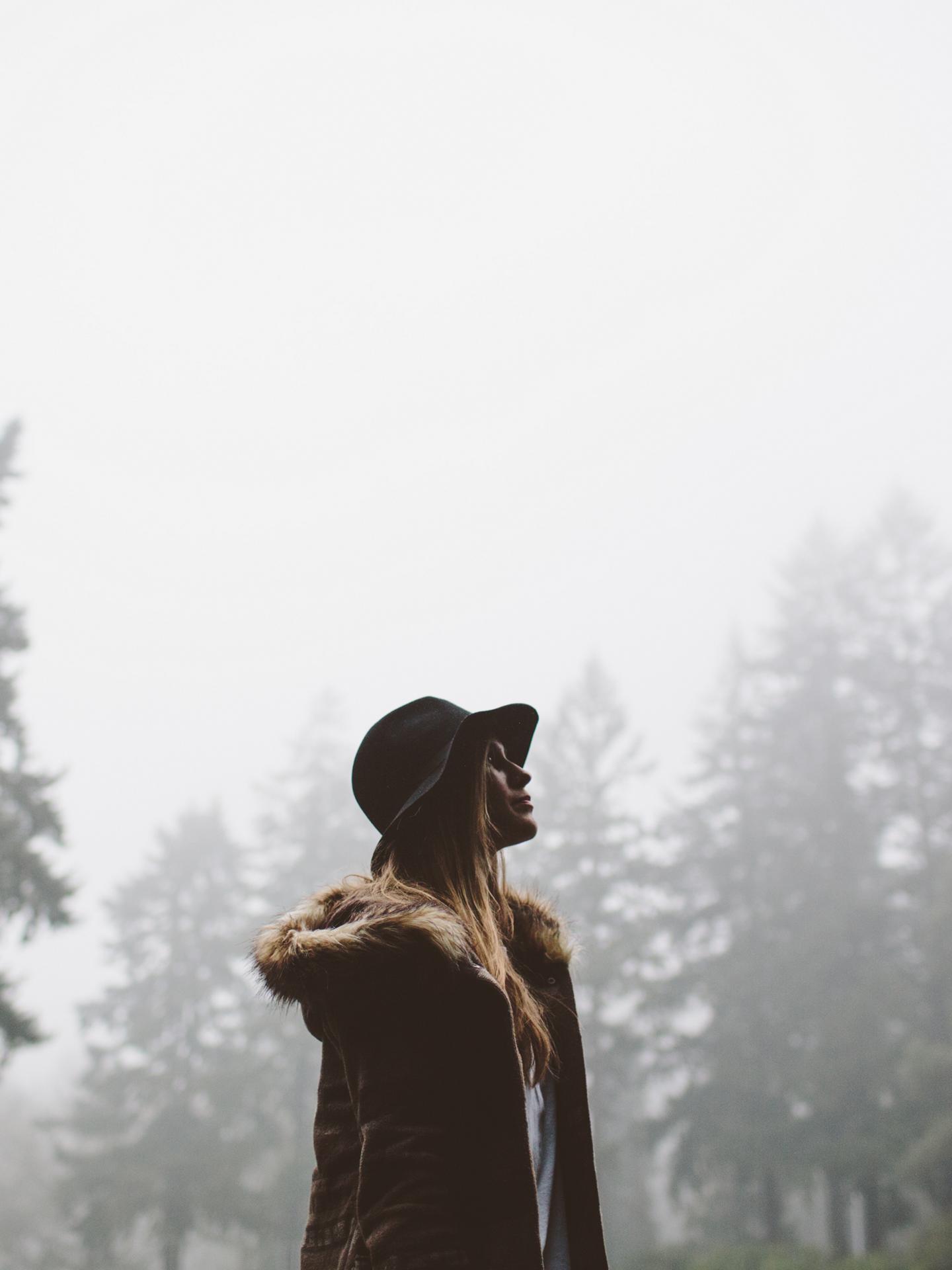 A woman walks through the forest following the conclusion of a rain storm