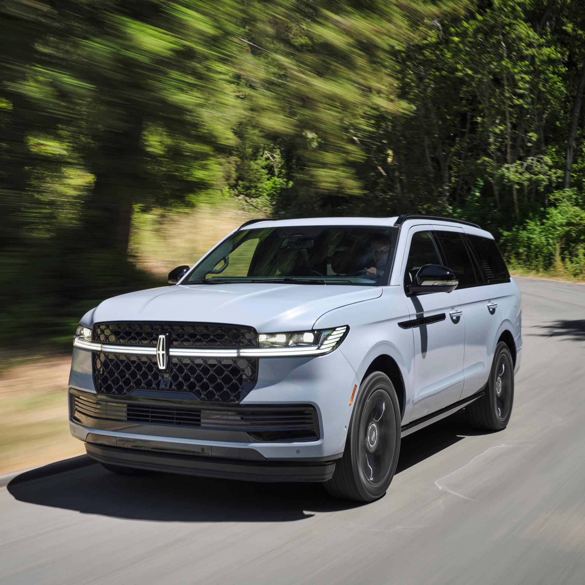 A 2026 Lincoln Navigator® SUV is being driven on a country road