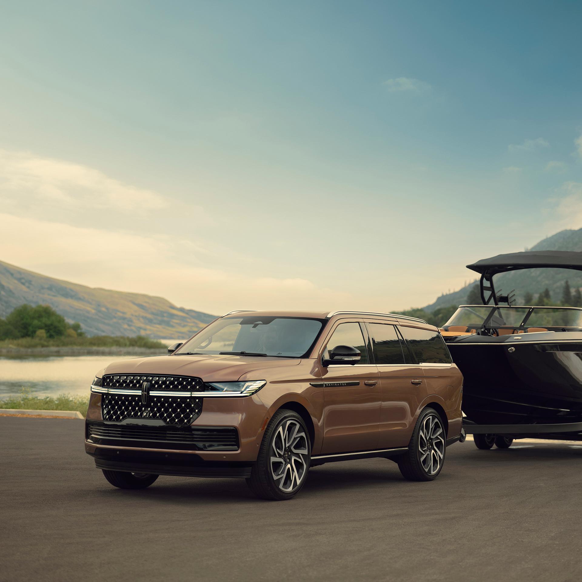 Una Lincoln Navigator® Black Label™ 2027 tiene un bote enganchado junto al agua
