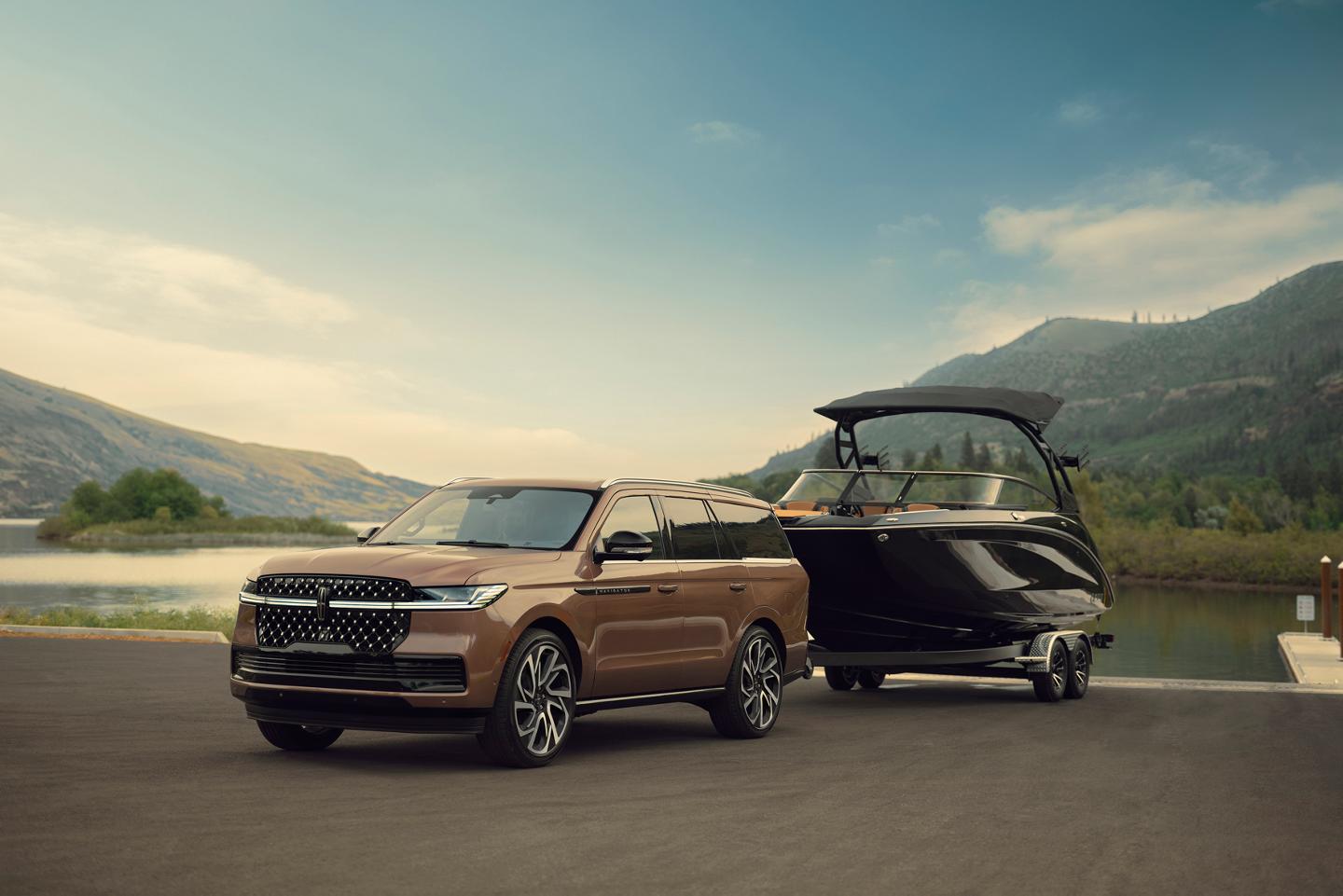 Una Lincoln Navigator® Black Label™ 2027 tiene un bote enganchado junto al agua