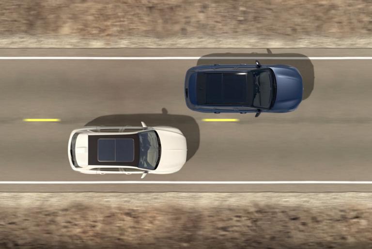 An overhead illustration of two cars being driven indicates how blind spot detection operates