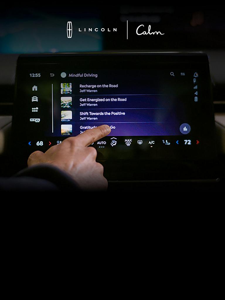 A finger interacts with an in-vehicle touchscreen interact with the calm app