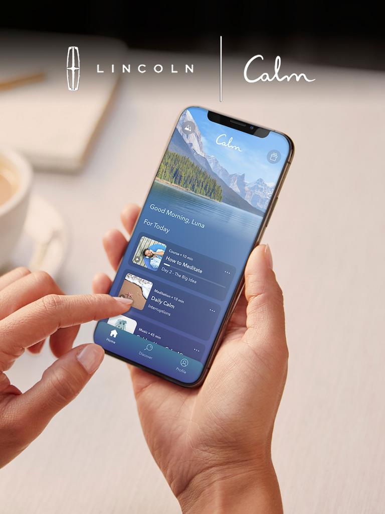 A finger interacts with an in-vehicle touchscreen to interact with the calm app