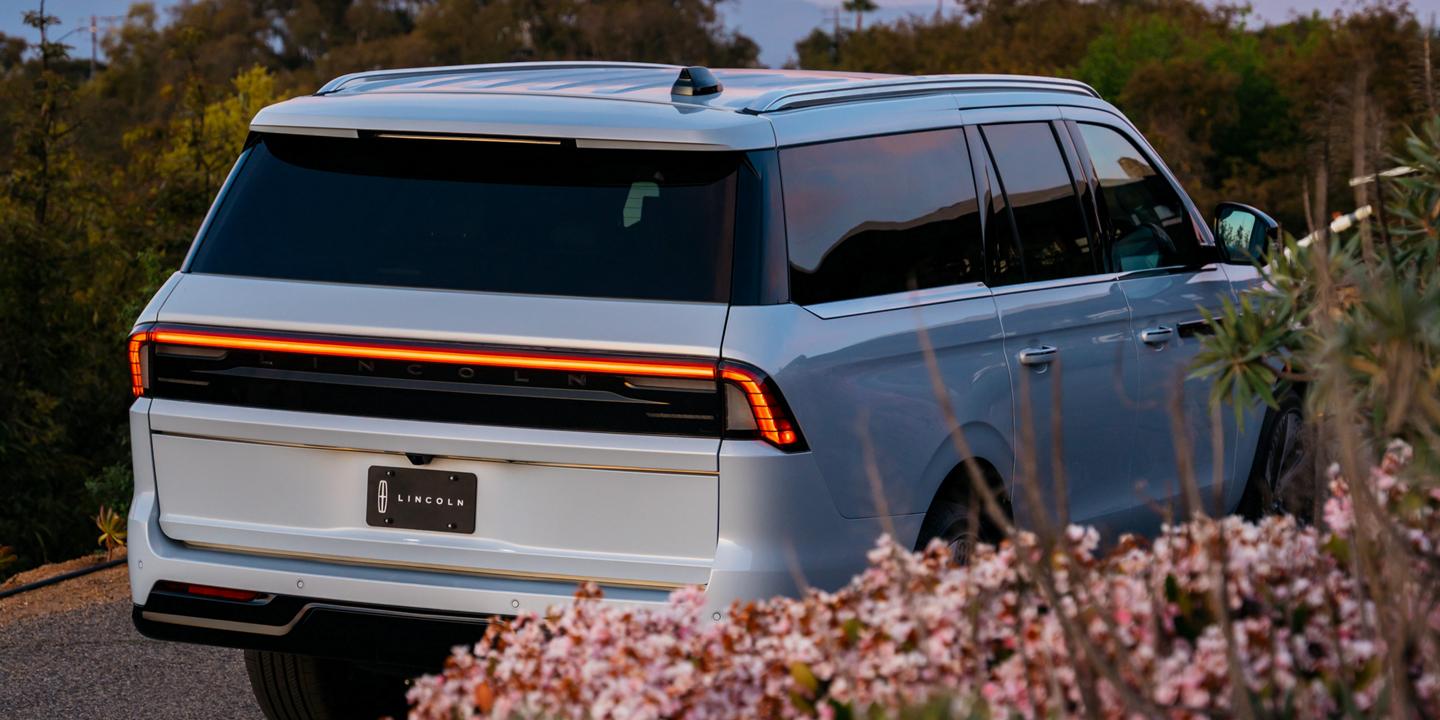 A rear shot of a 2027 Lincoln Navigator® SUV with the taillights illuminated