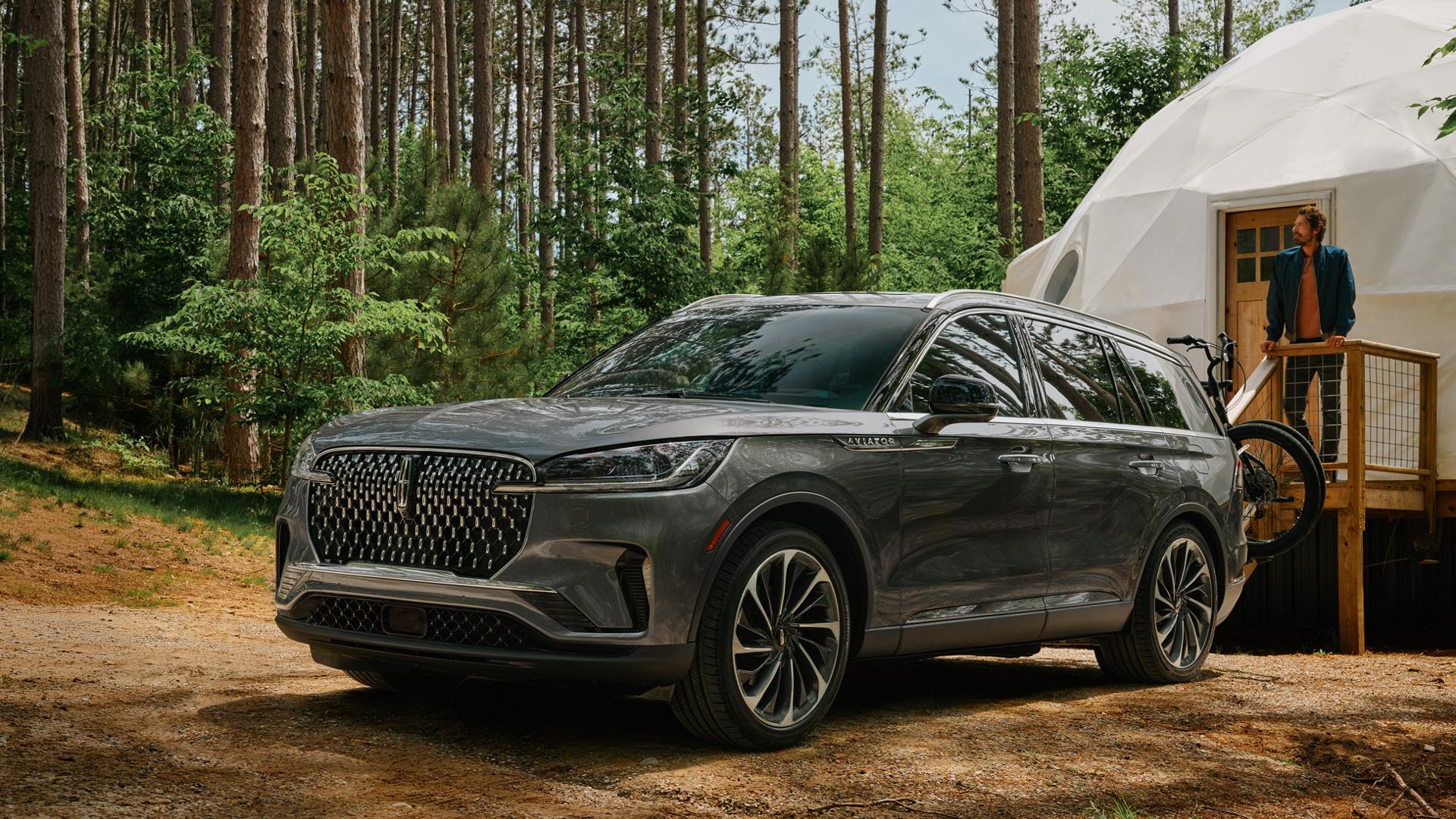A 2027 Lincoln Aviator® SUV is parked next to a luxurious glamping site
