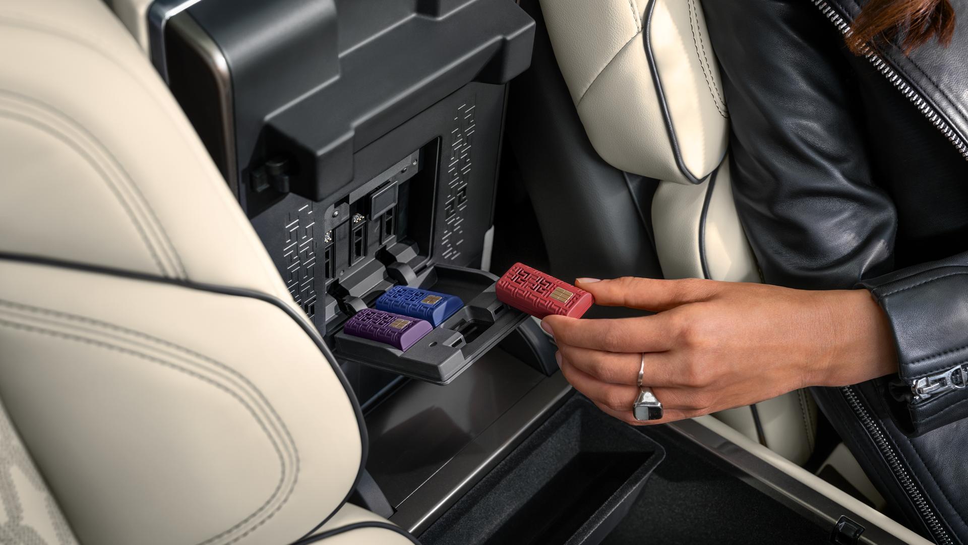 A hand places a digital scent cartridge into the center console of a 2026 Lincoln Nautilus® SUV