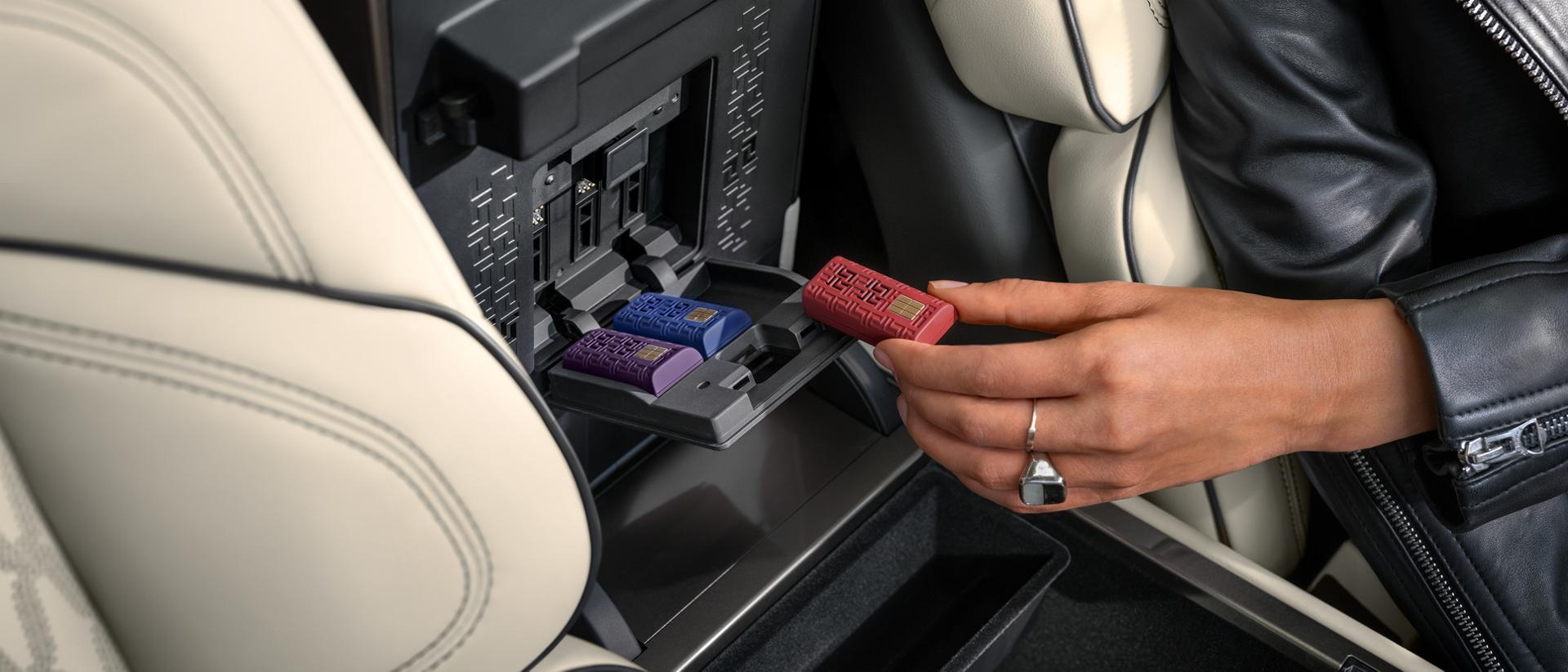 Una persona inserta un cartucho de aroma digital en la consola central de una SUV Lincoln