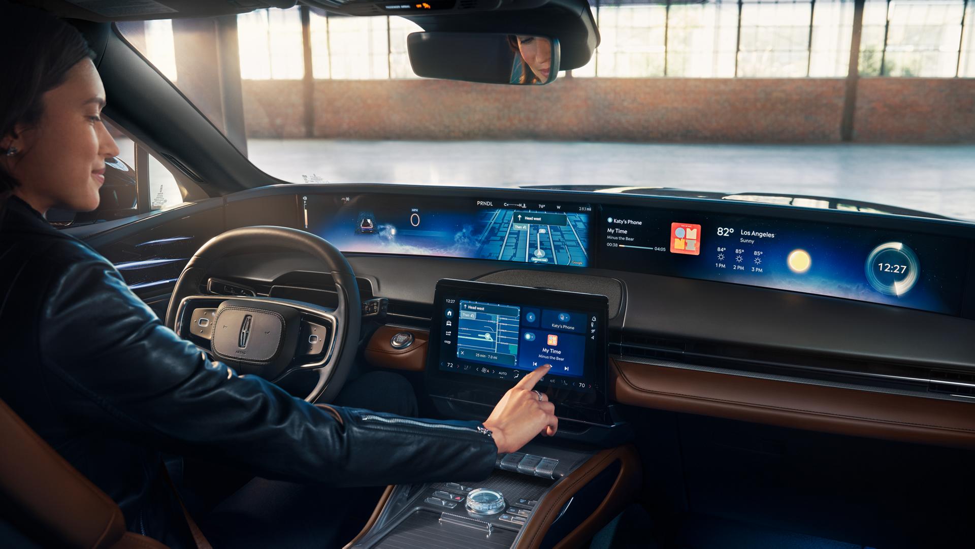 A person seated in the drivers seat of a 2026 Lincoln Nautilus® SUV touches the center screen