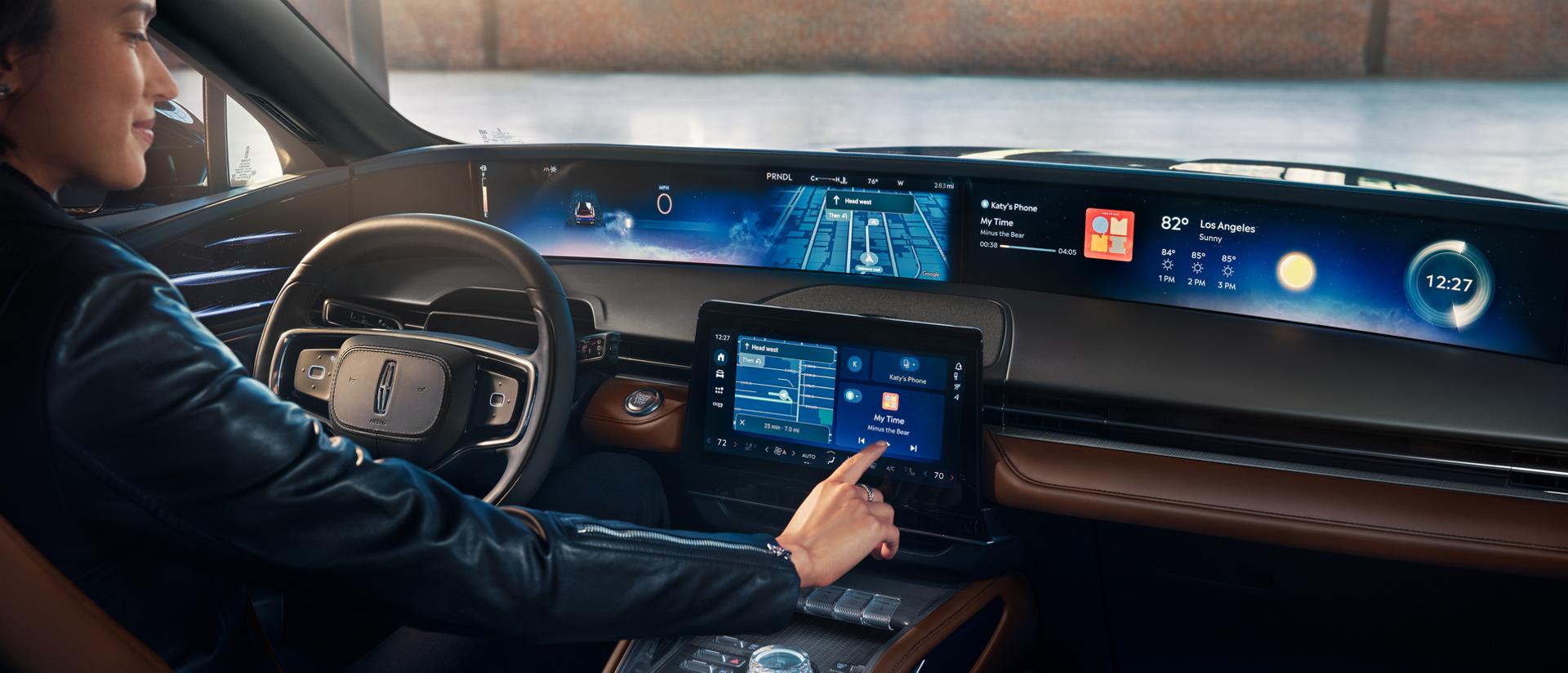 A person seated in the drivers seat of a 2026 Lincoln Nautilus® SUV touches the center screen