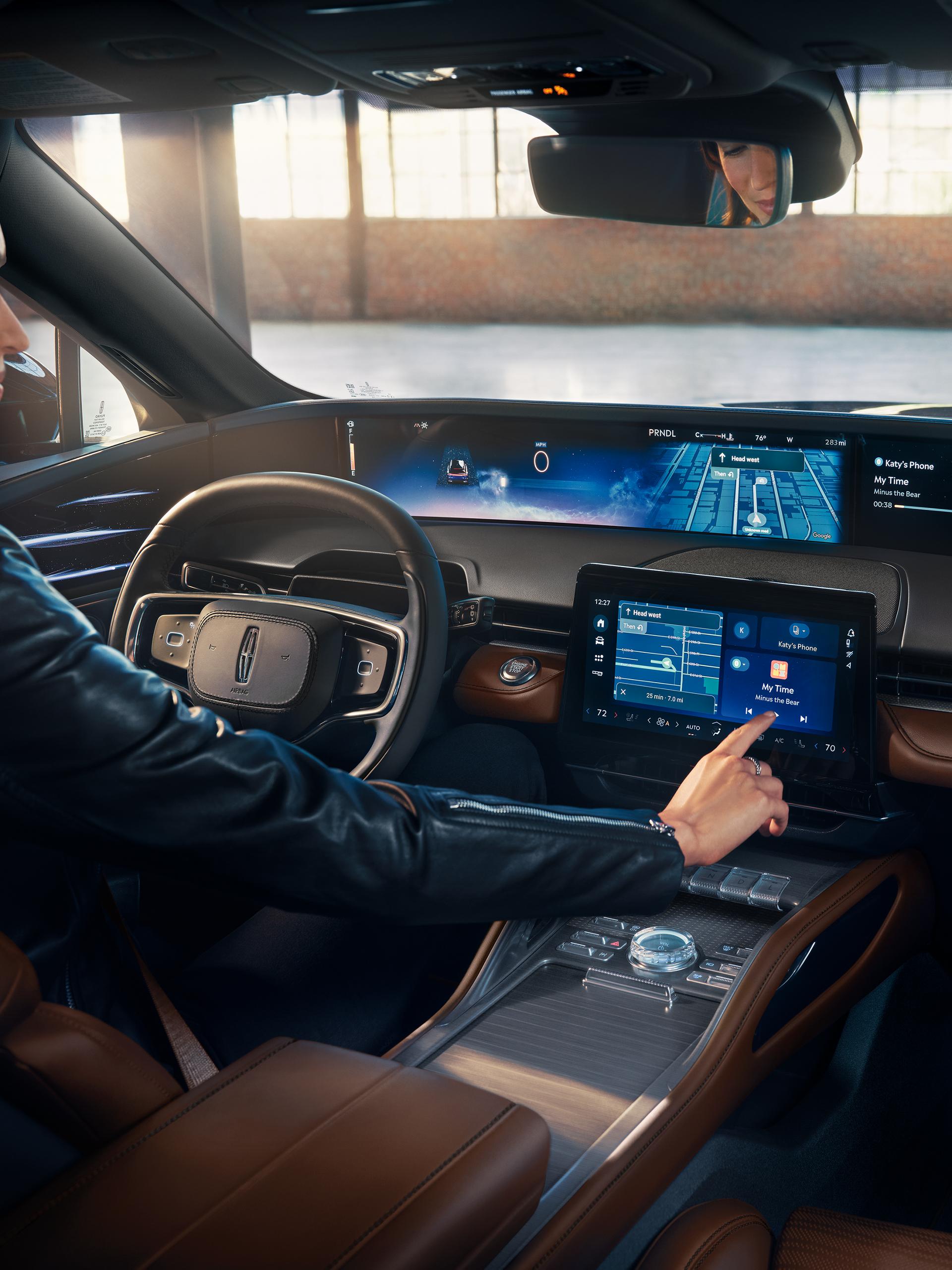 A person seated in the drivers seat of a 2026 Lincoln Nautilus® SUV touches the center screen