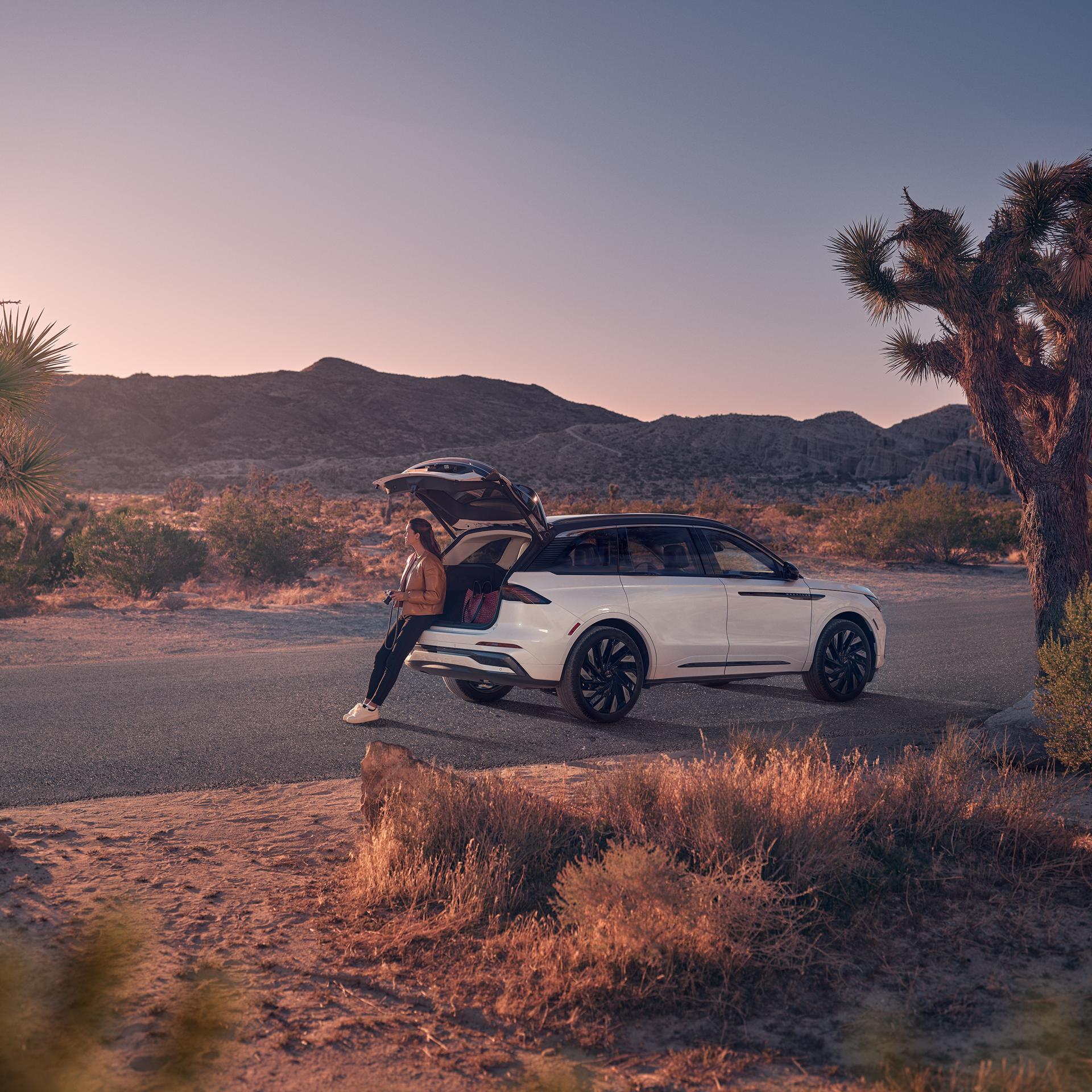 A woman sits in the rear cargo area of a 2026 Lincoln Nautilus® SUV