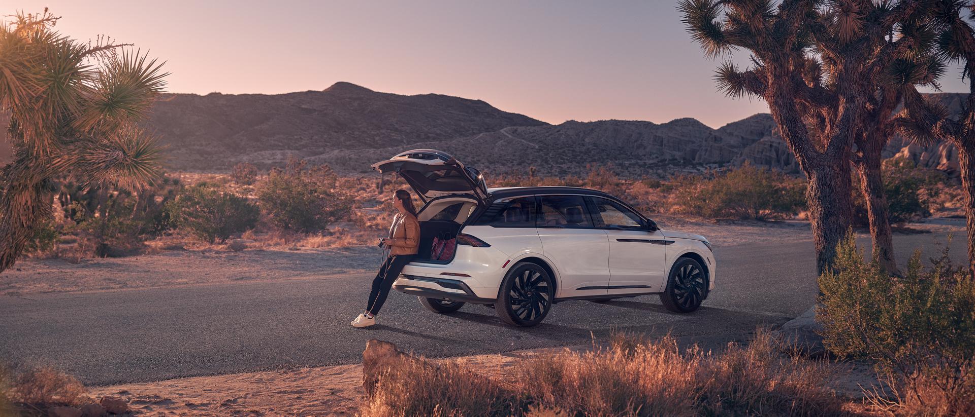 Una mujer está sentada en el área de carga trasera de una SUV Lincoln Nautilus® 2026