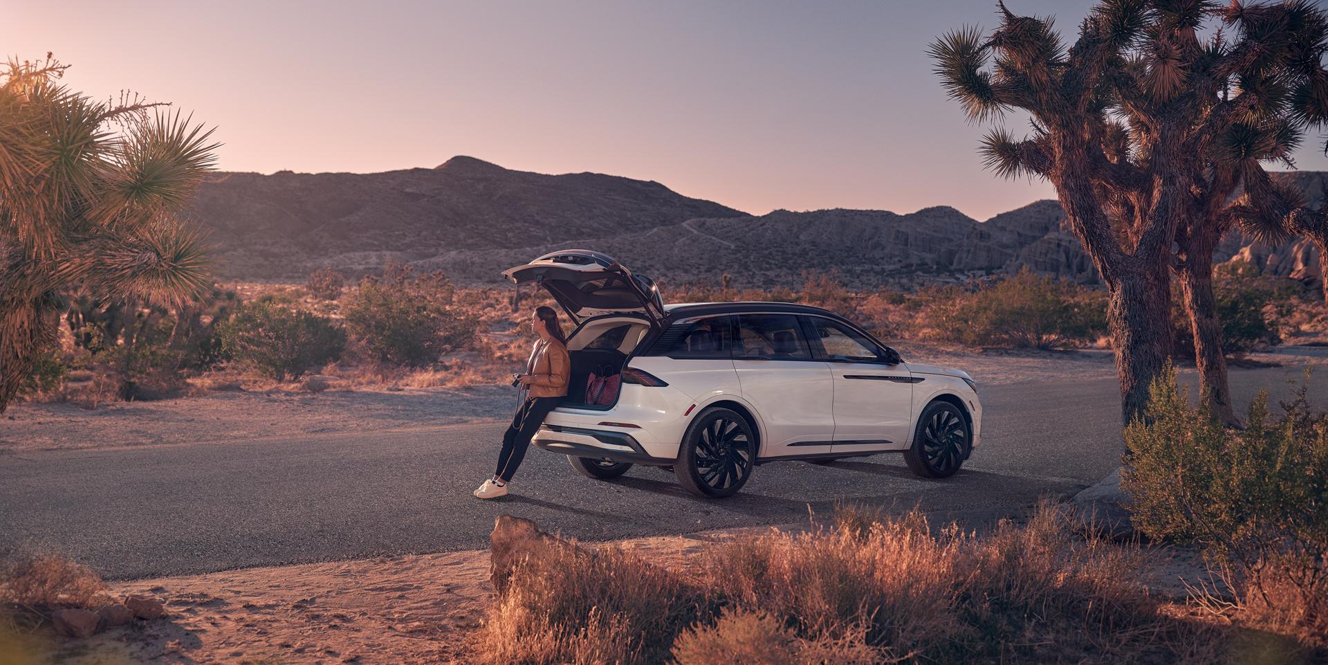 A woman sits in the rear cargo area of a 2026 Lincoln Nautilus® SUV