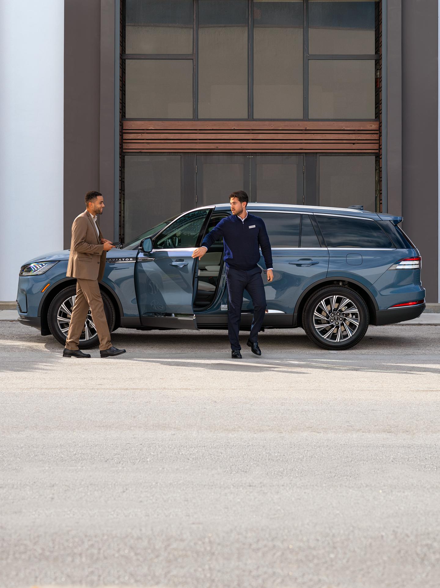 Un empleado de Lincoln entregando un vehículo Lincoln a su dueño.