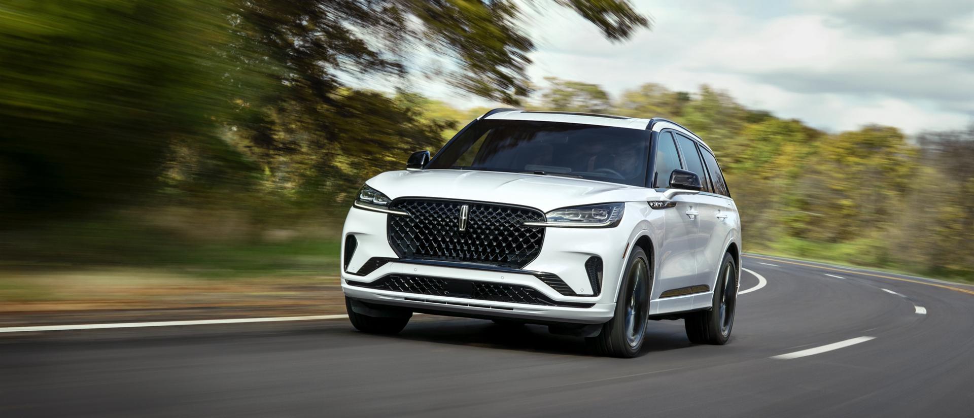 A 2026 Lincoln Aviator® SUV is being driven on a country road